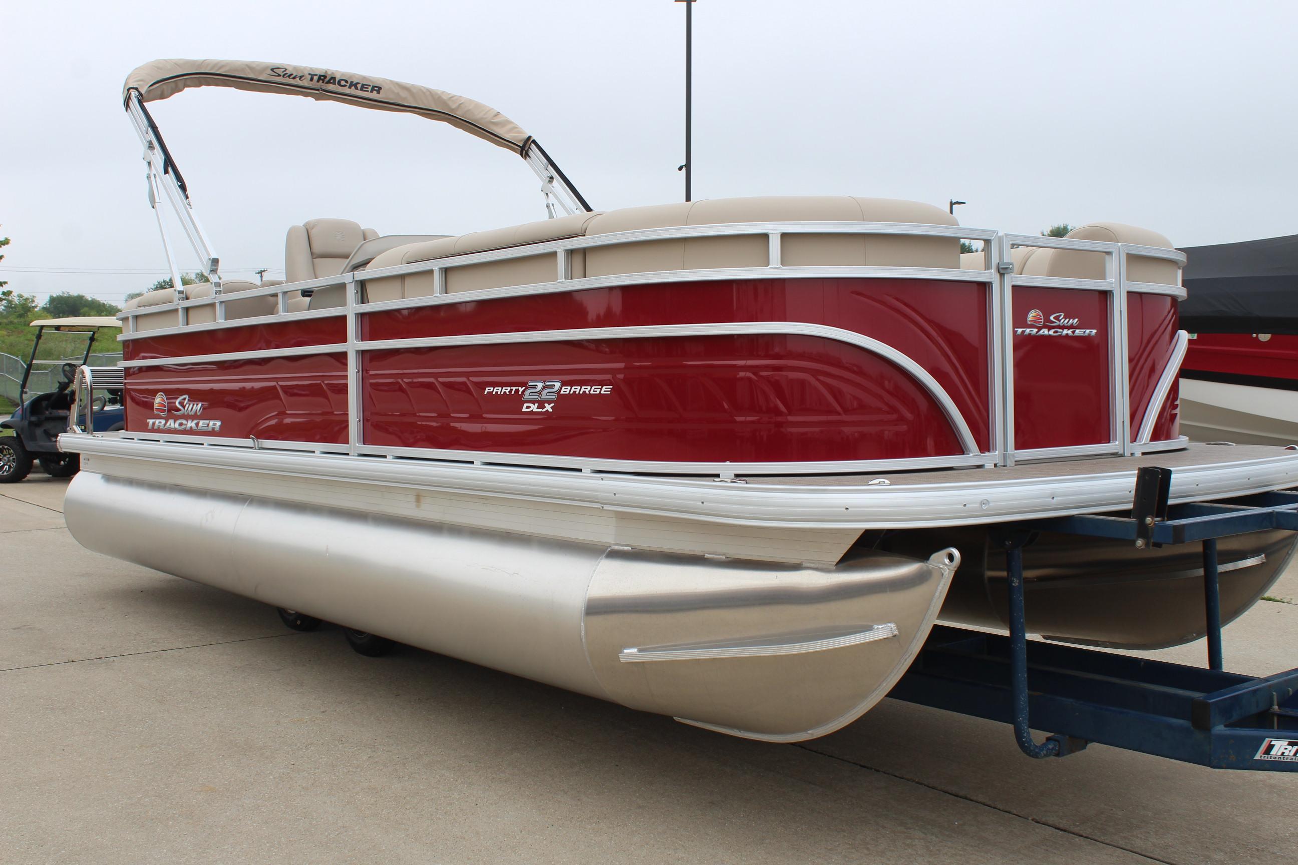 2025 Sun Tracker Party Barge 22 DLX pontoon boat with red exterior on trailer.