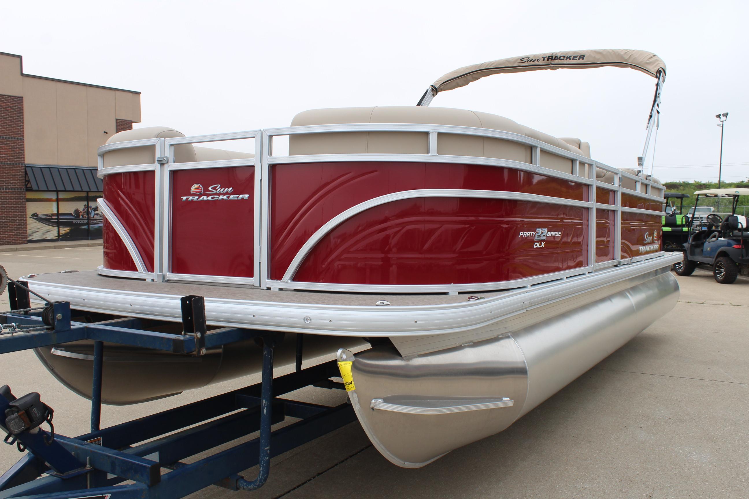 2025 Sun Tracker Party Barge 22 DLX pontoon boat on trailer, red and silver design.