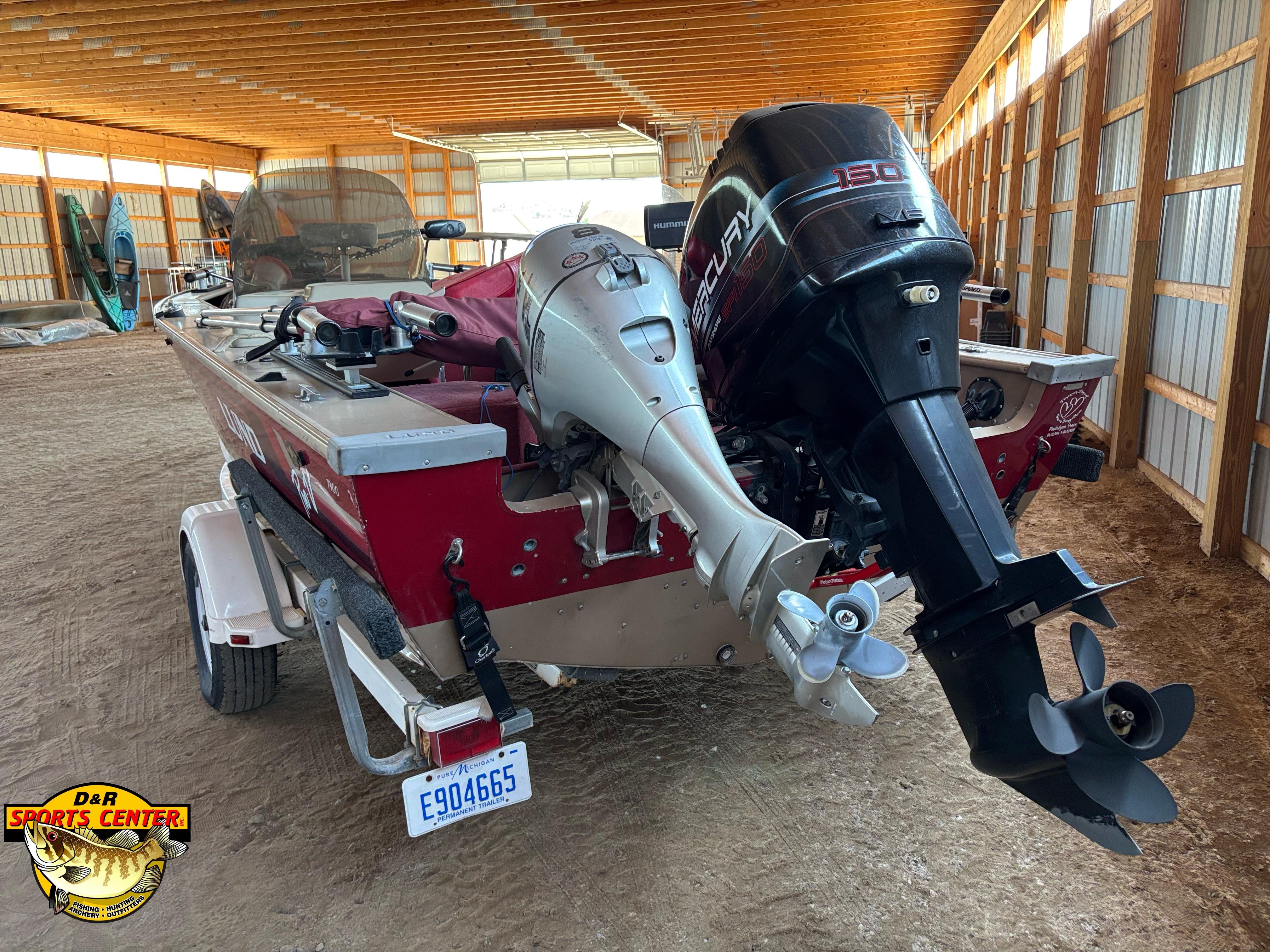 1997 Lund 1900 Pro-V LE boat with dual outboard motors in a storage facility.
