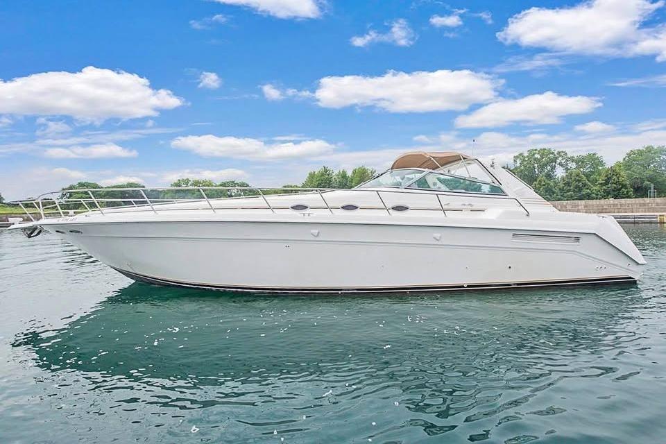 1998 Sea Ray 500 Sundancer yacht on calm water under a blue sky.