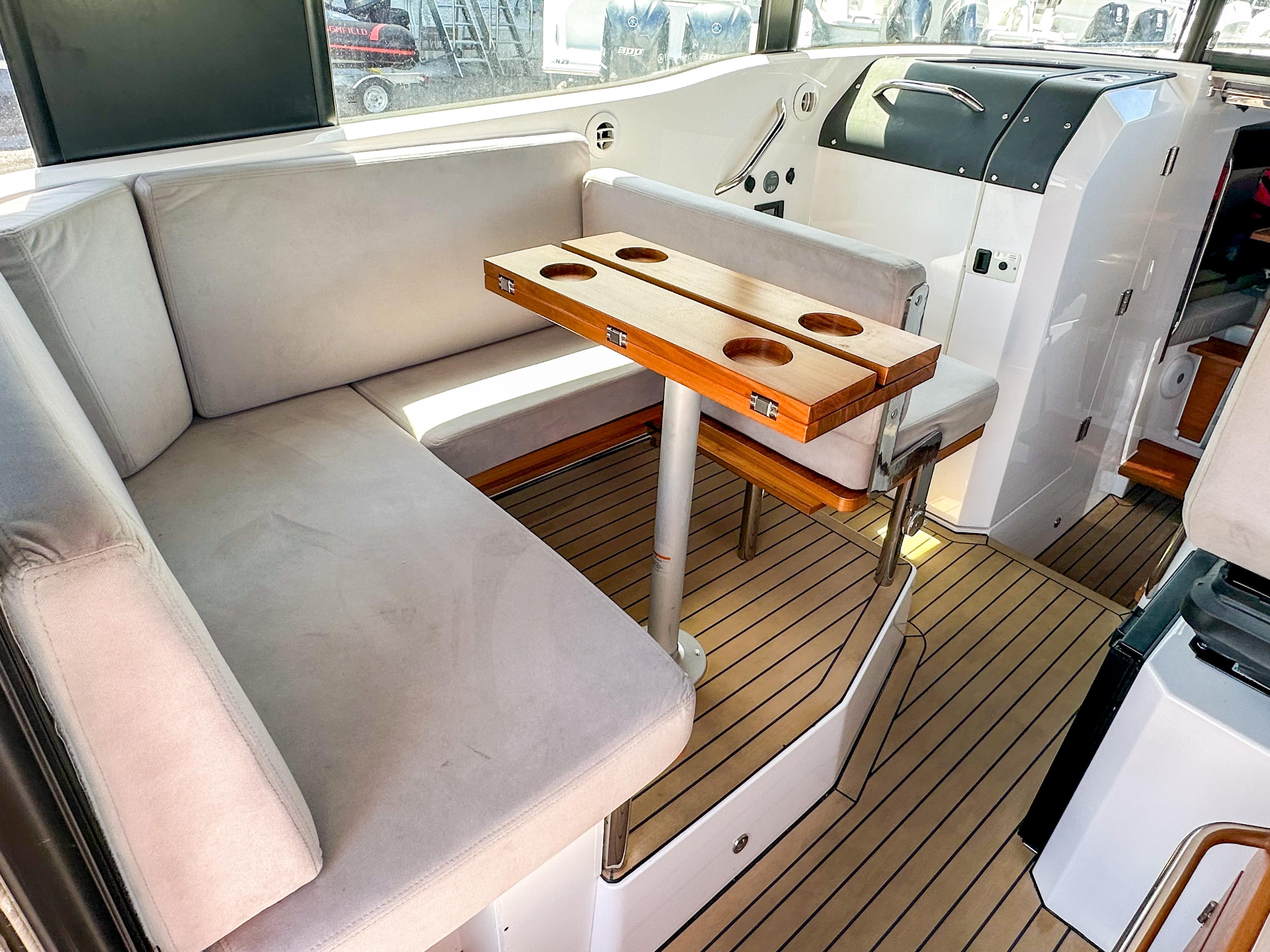 XO Boats-EXPLR 10 Sport Plus 2024 -FL-US-2024 XO Boats EXPLR 10 Sport Plus interior with cushioned seating and wooden table.-9818089 | Thumbnail