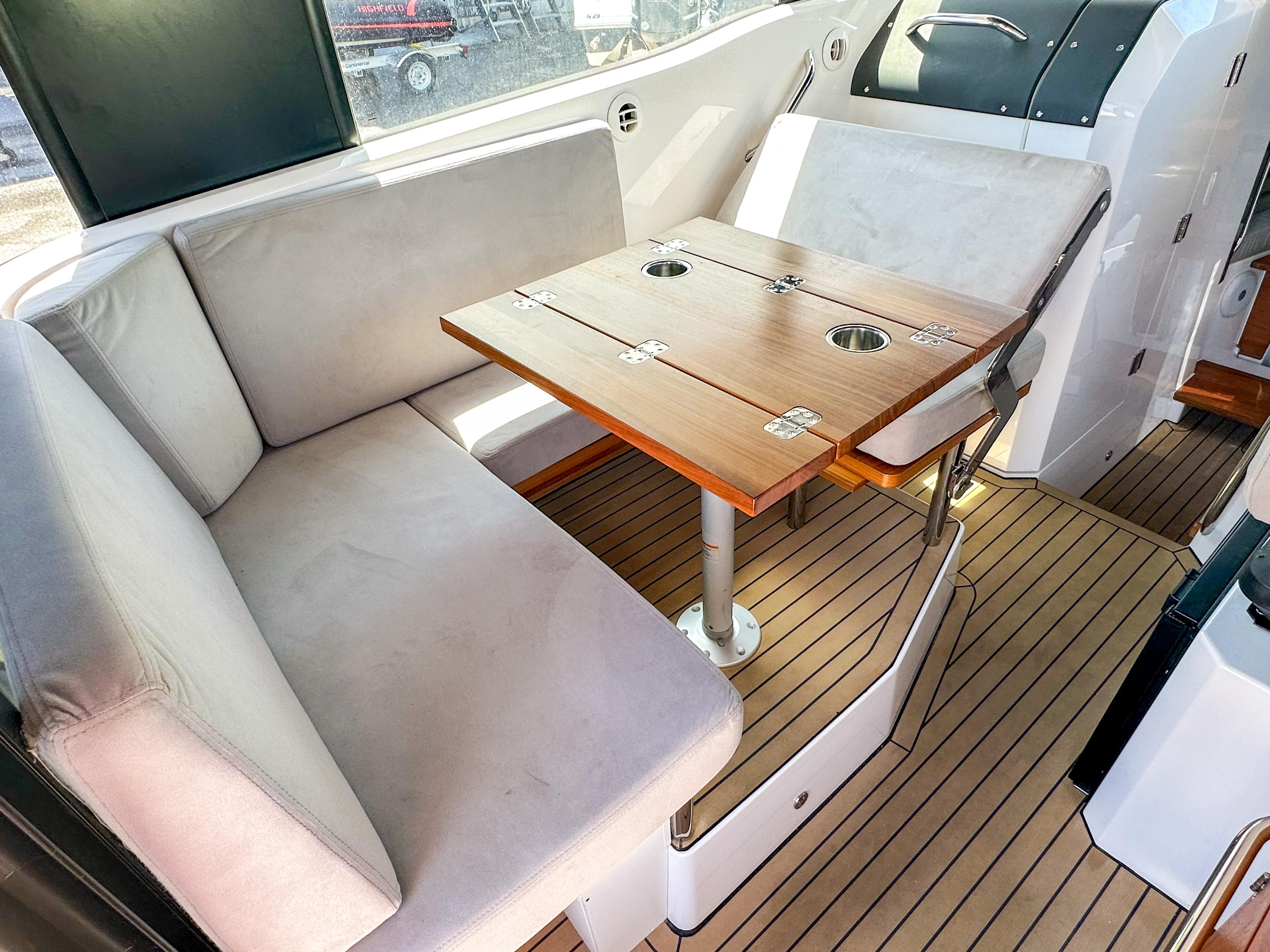 XO Boats-EXPLR 10 Sport Plus 2024 -FL-US-2024 XO Boats EXPLR 10 Sport Plus interior with cushioned seating and wooden table.-9818089 | Thumbnail