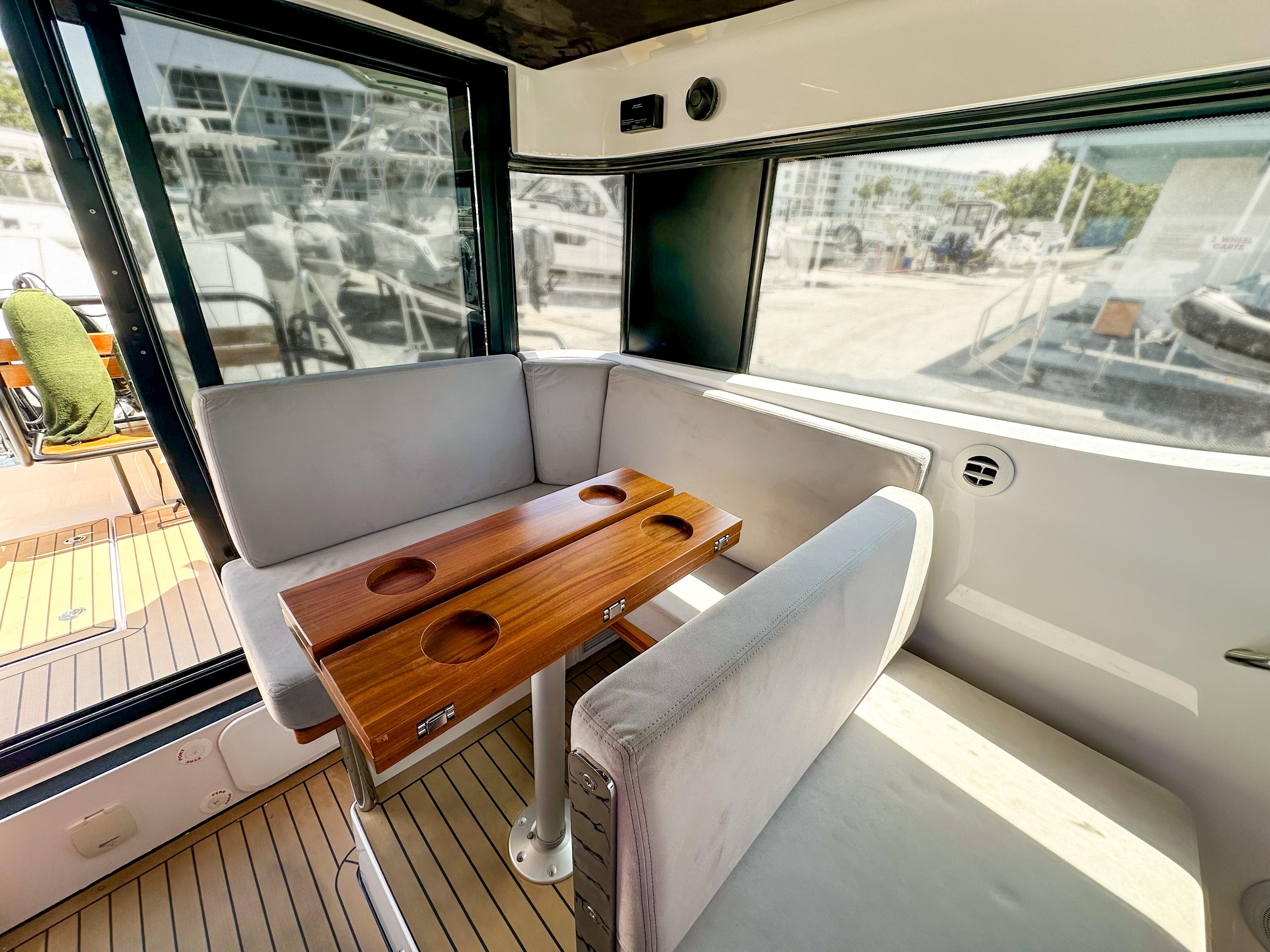 XO Boats-EXPLR 10 Sport Plus 2024 -FL-US-2024 XO Boats EXPLR 10 Sport Plus interior with seating and wooden table.-9818089 | Thumbnail
