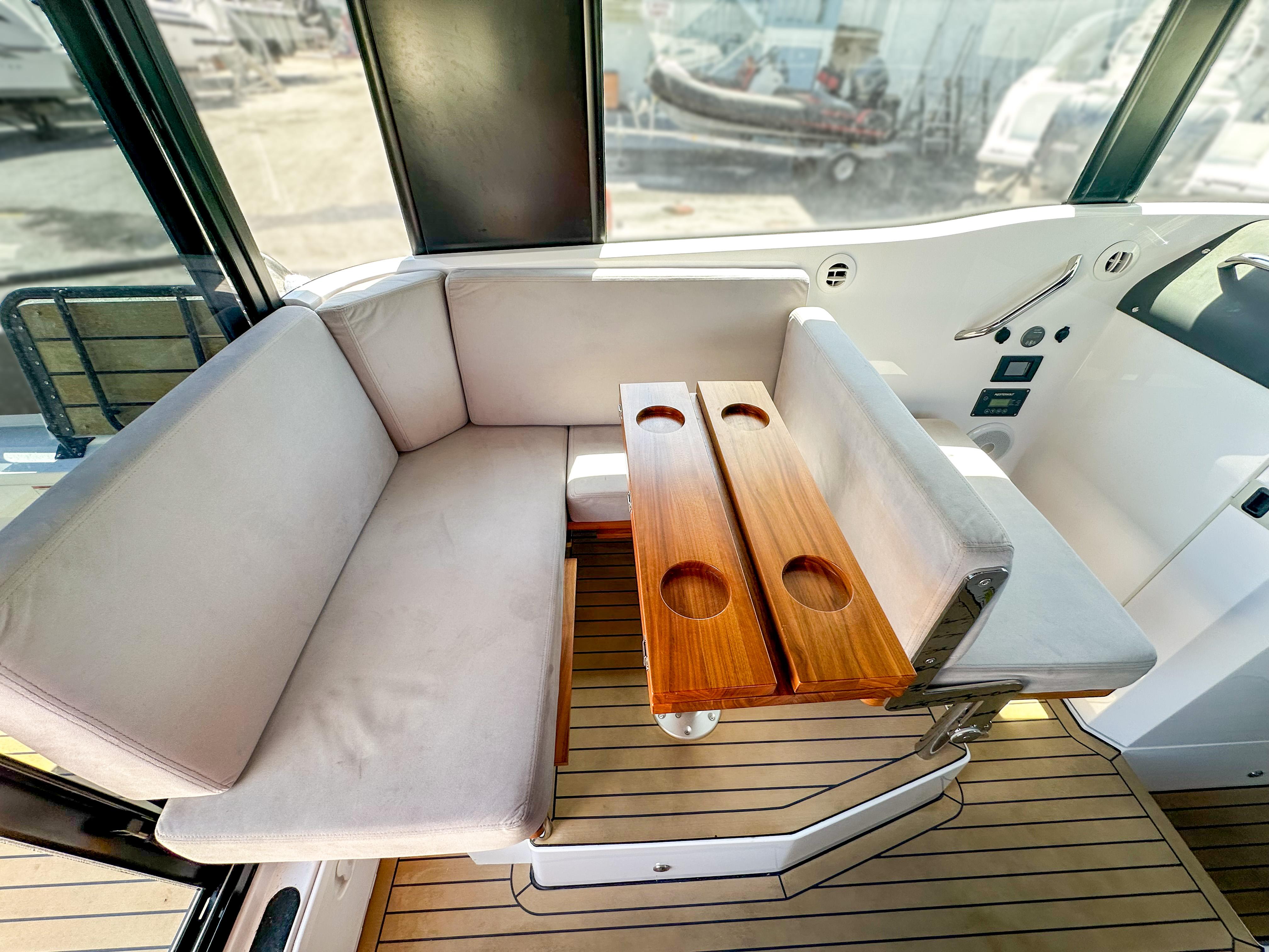 XO Boats-EXPLR 10 Sport Plus 2024 -FL-US-2024 XO Boats EXPLR 10 Sport Plus interior with cushioned seating and wooden table.-9818089 | Thumbnail