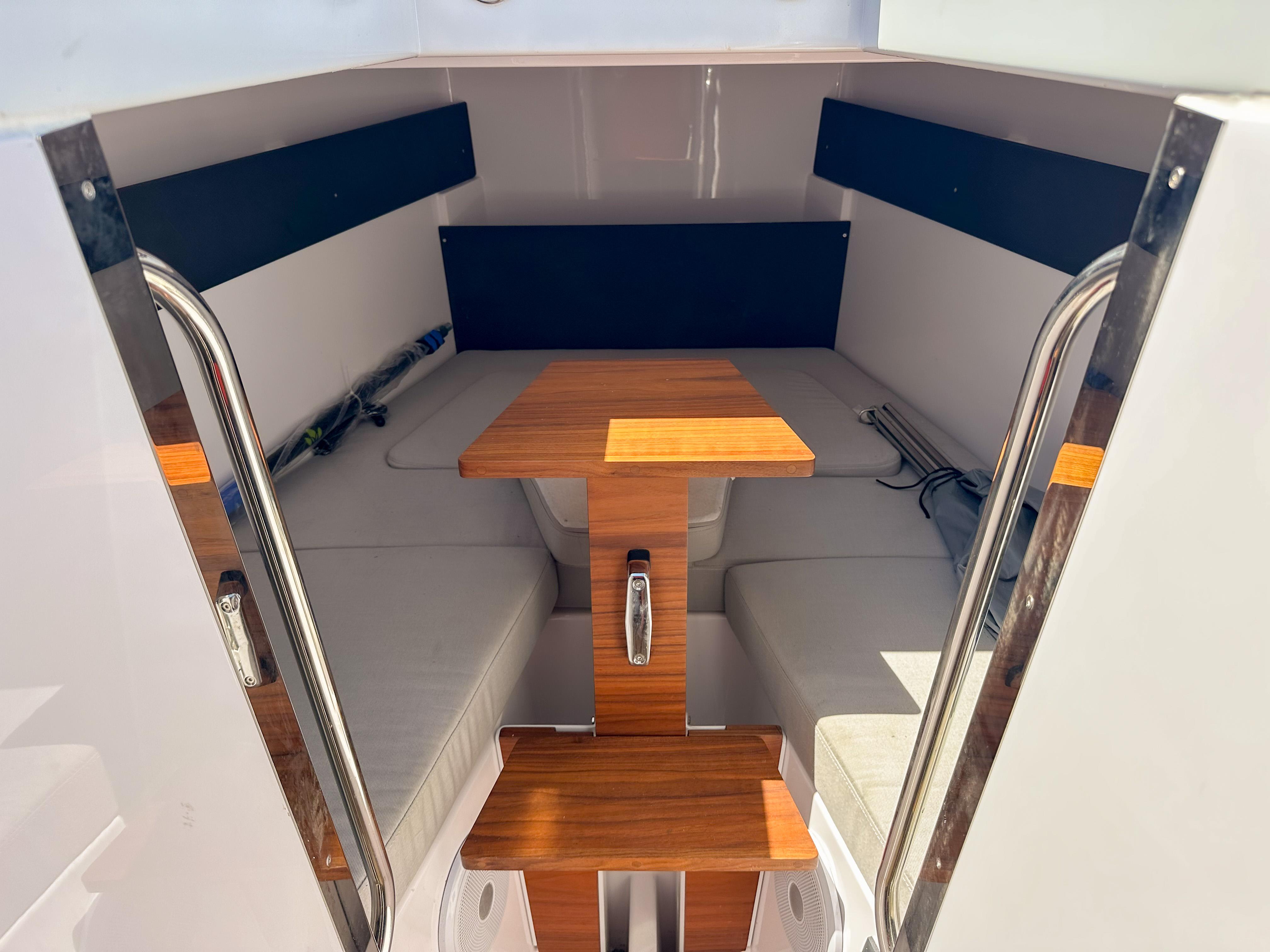 XO Boats-EXPLR 10 Sport Plus 2024 -FL-US-2024 XO Boats EXPLR 10 Sport Plus cabin interior with wooden table and seating.-9818089 | Thumbnail