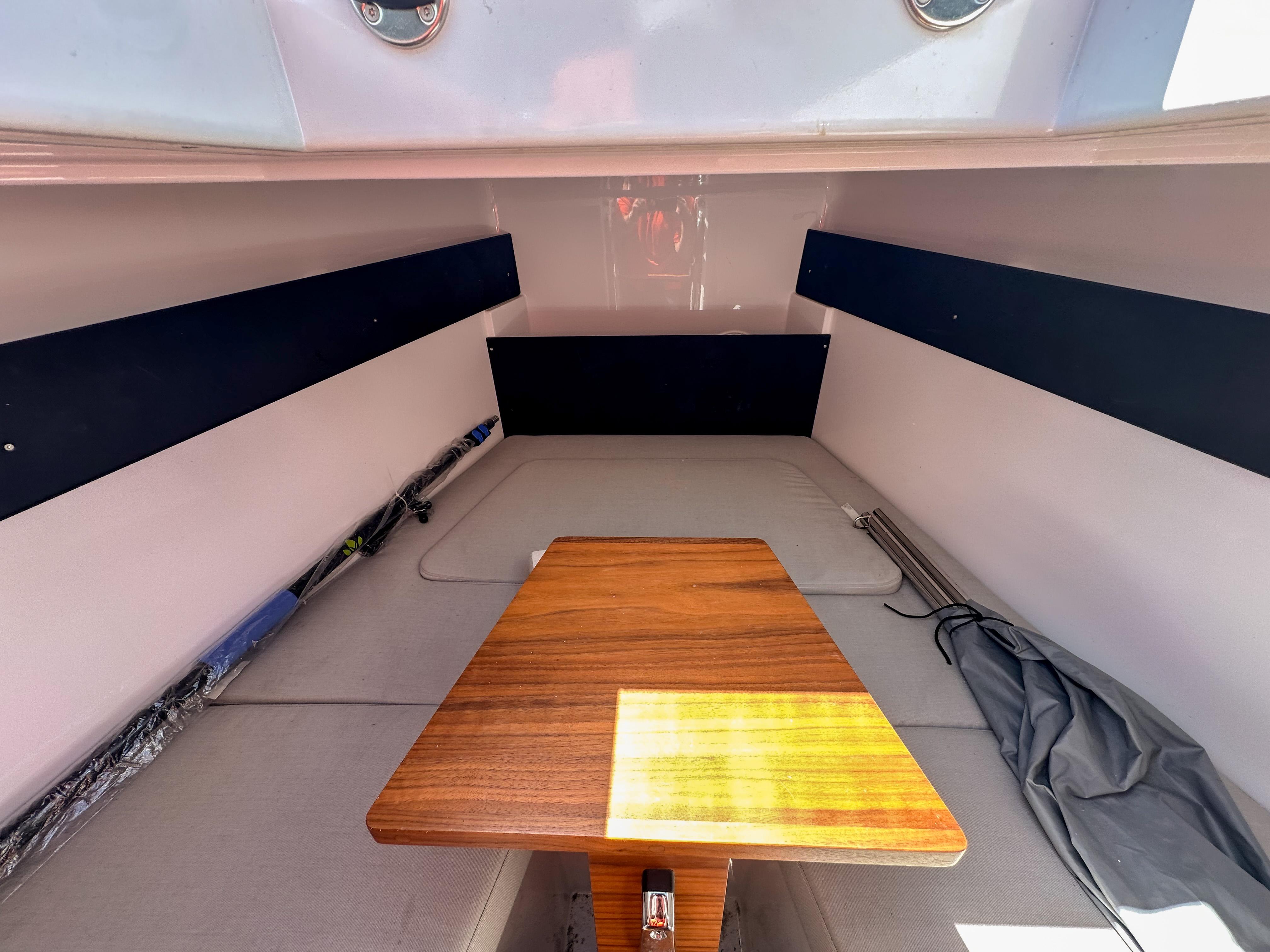 XO Boats-EXPLR 10 Sport Plus 2024 -FL-US-2024 XO Boats EXPLR 10 Sport Plus cabin interior with wooden table and seating.-9818089 | Thumbnail