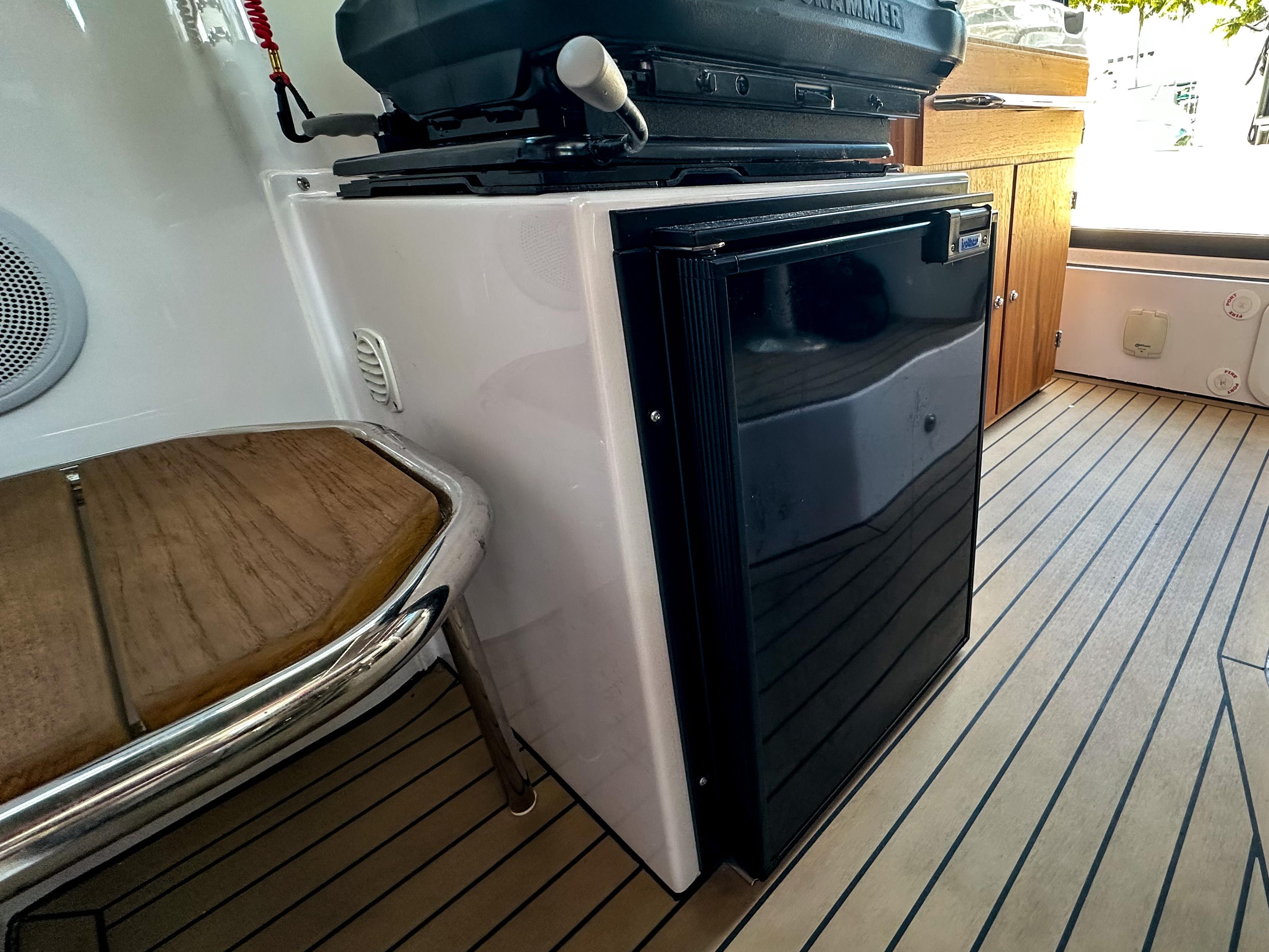 XO Boats-EXPLR 10 Sport Plus 2024 -FL-US-2024 XO Boats EXPLR 10 Sport Plus interior with compact fridge and wooden flooring.-9818089 | Thumbnail