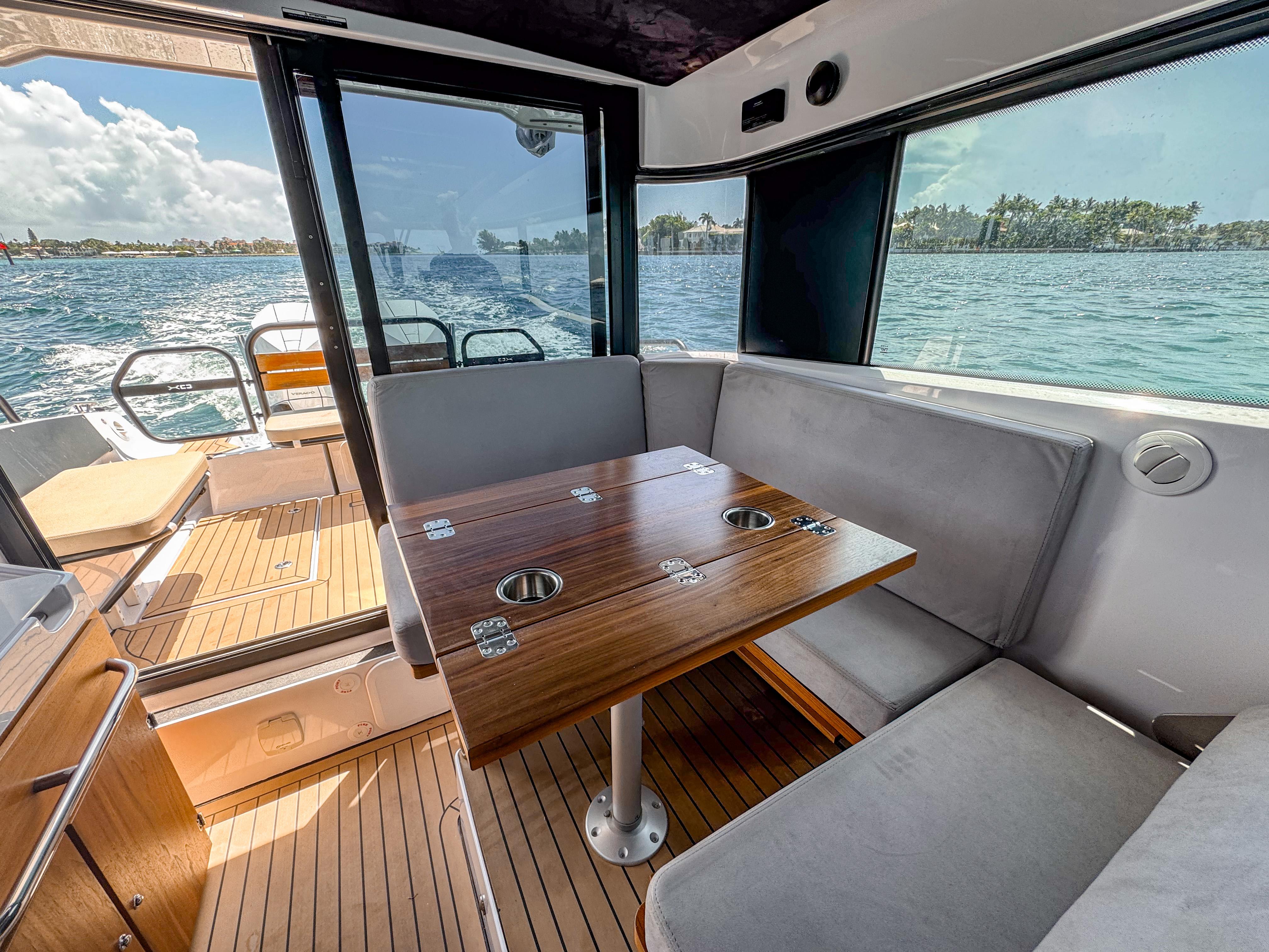 XO Boats-XO Boats EXPLR 10S Plus 2024 -FL-US-2024 XO Boats EXPLR 10S Plus interior with wooden table and seating, overlooking water.-9818089 | Thumbnail