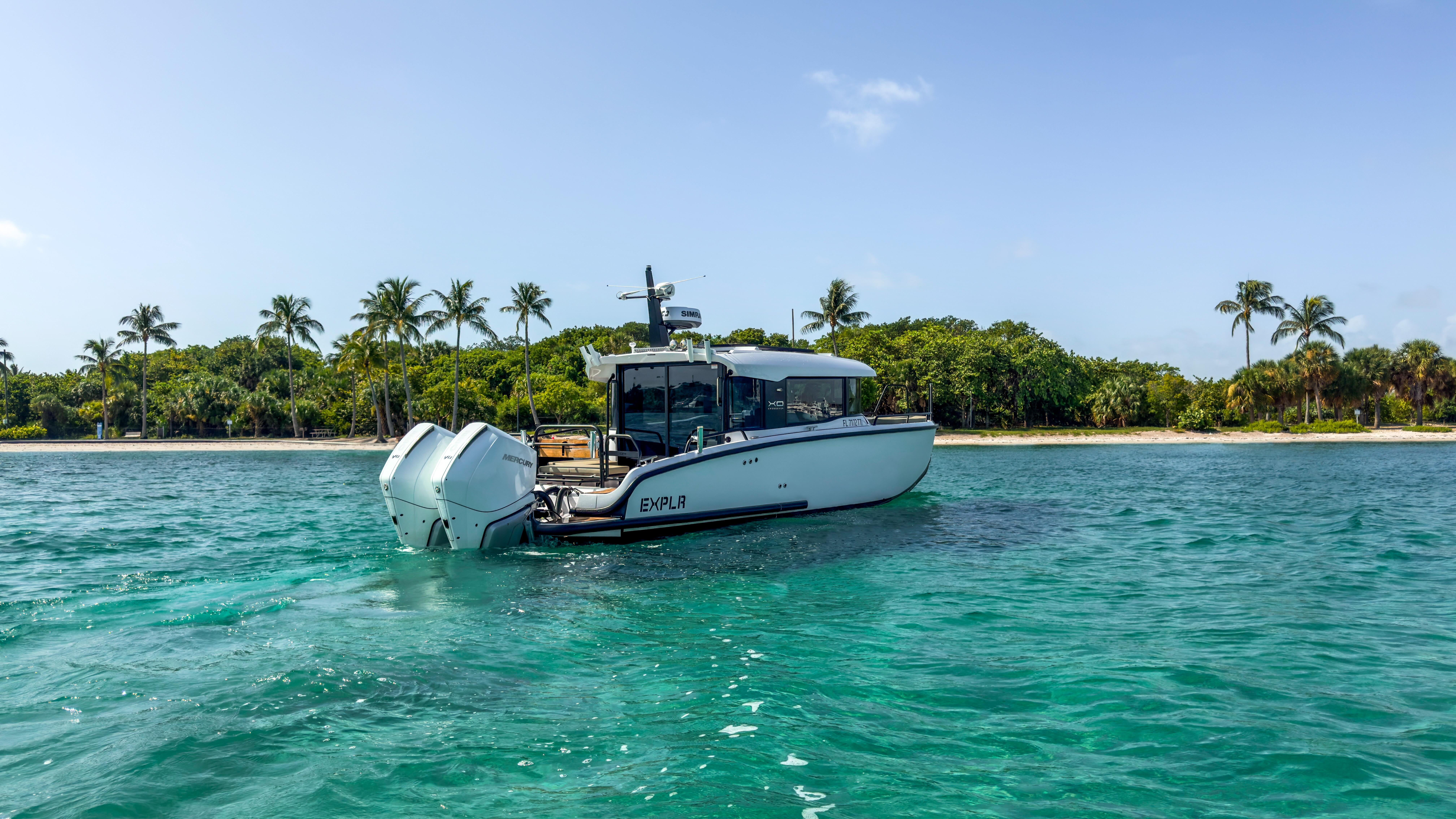 XO Boats-XO Boats EXPLR 10S Plus 2024 -FL-US-2024 XO Boats EXPLR 10S Plus cruising near a tropical shoreline with palm trees.-9818089 | Thumbnail