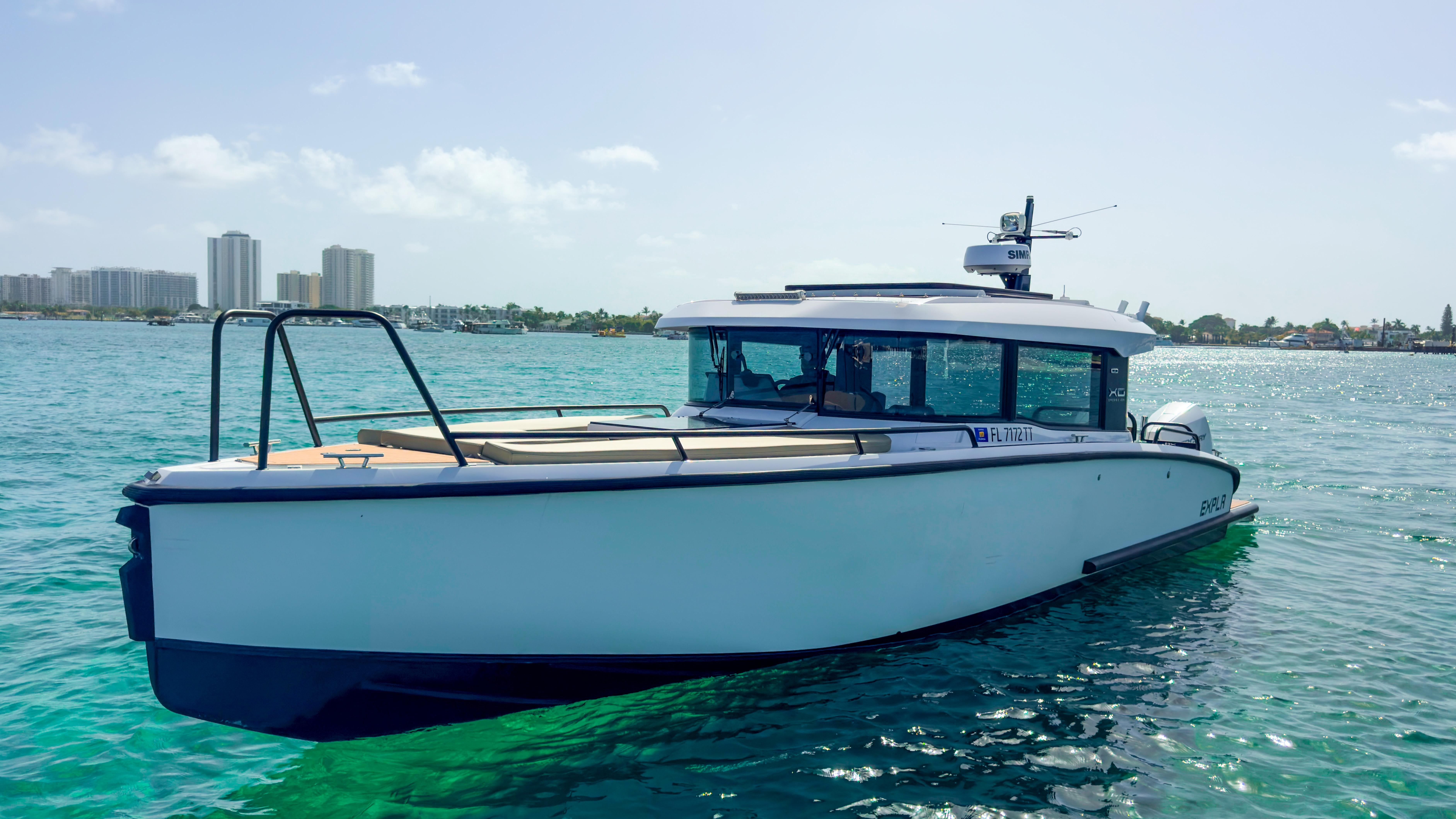 XO Boats-XO Boats EXPLR 10S Plus 2024 -FL-US-2024 XO Boats EXPLR 10S Plus on clear blue water, city skyline in background.-9818089 | Thumbnail
