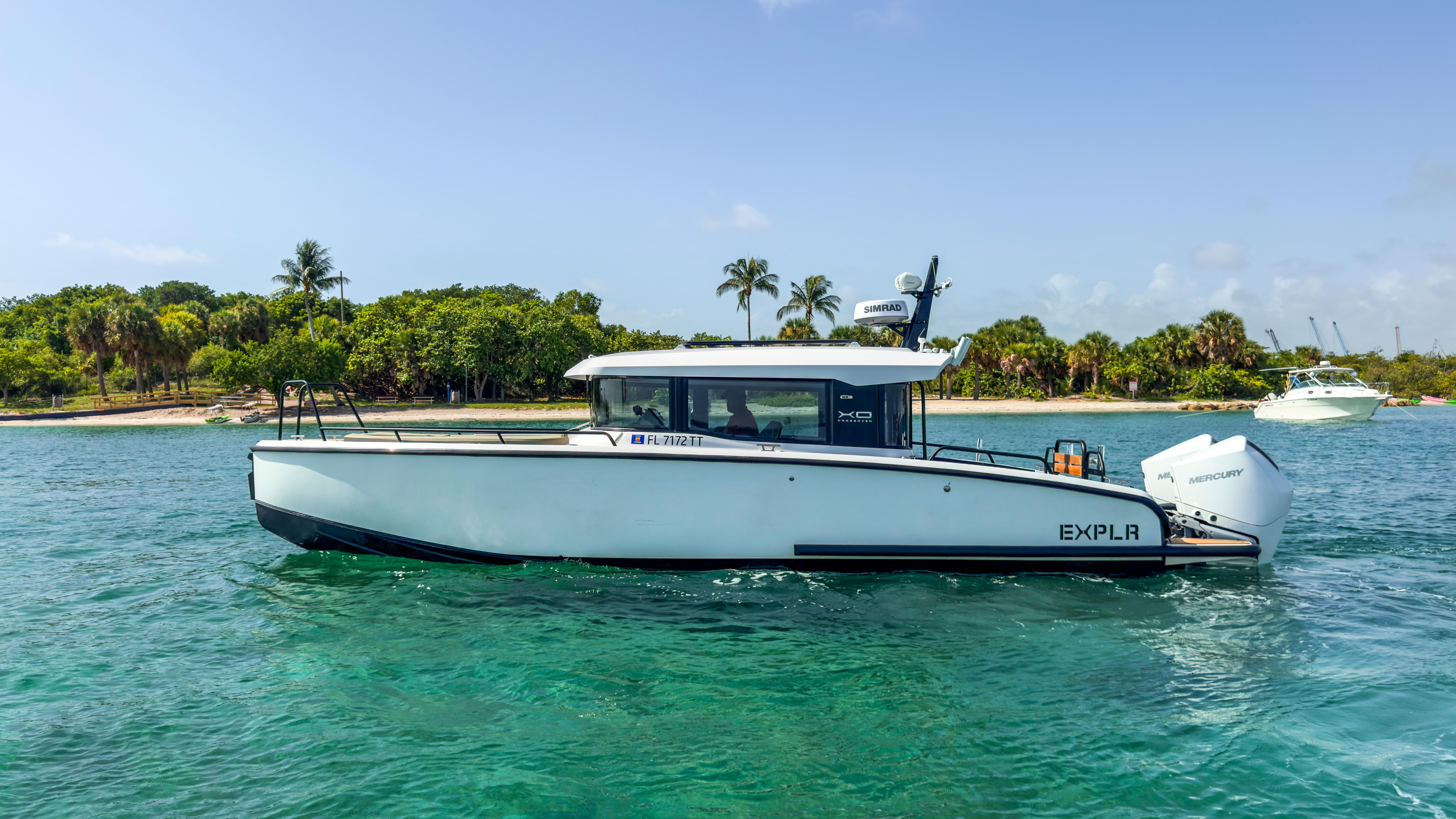 XO Boats-XO Boats EXPLR 10S Plus 2024 -FL-US-2024 XO Boats EXPLR 10S Plus cruising on clear blue water near a tropical shoreline.-9818089 | Thumbnail