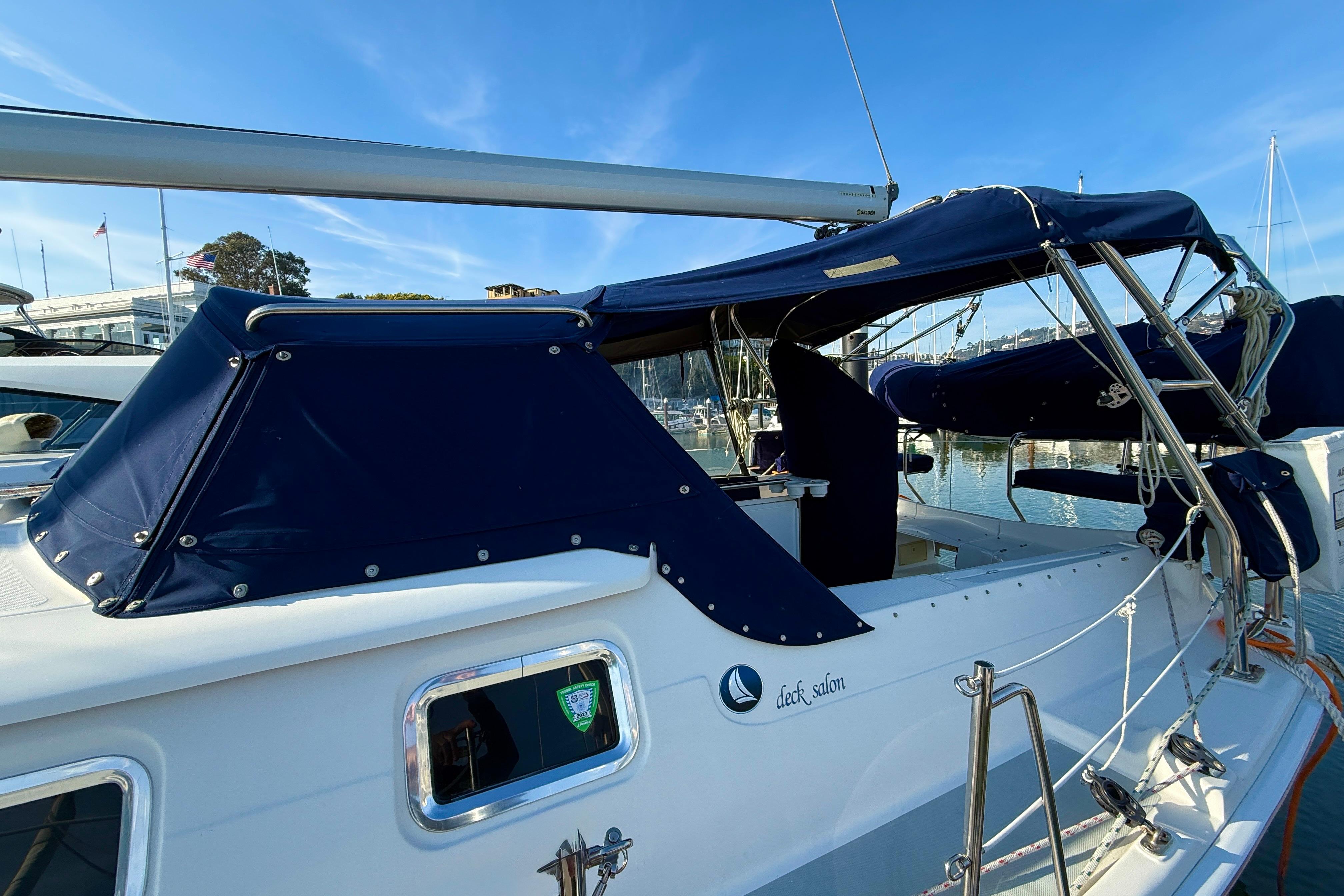 2007 Hunter 44 Deck Salon sailboat with blue canopy, docked in marina.