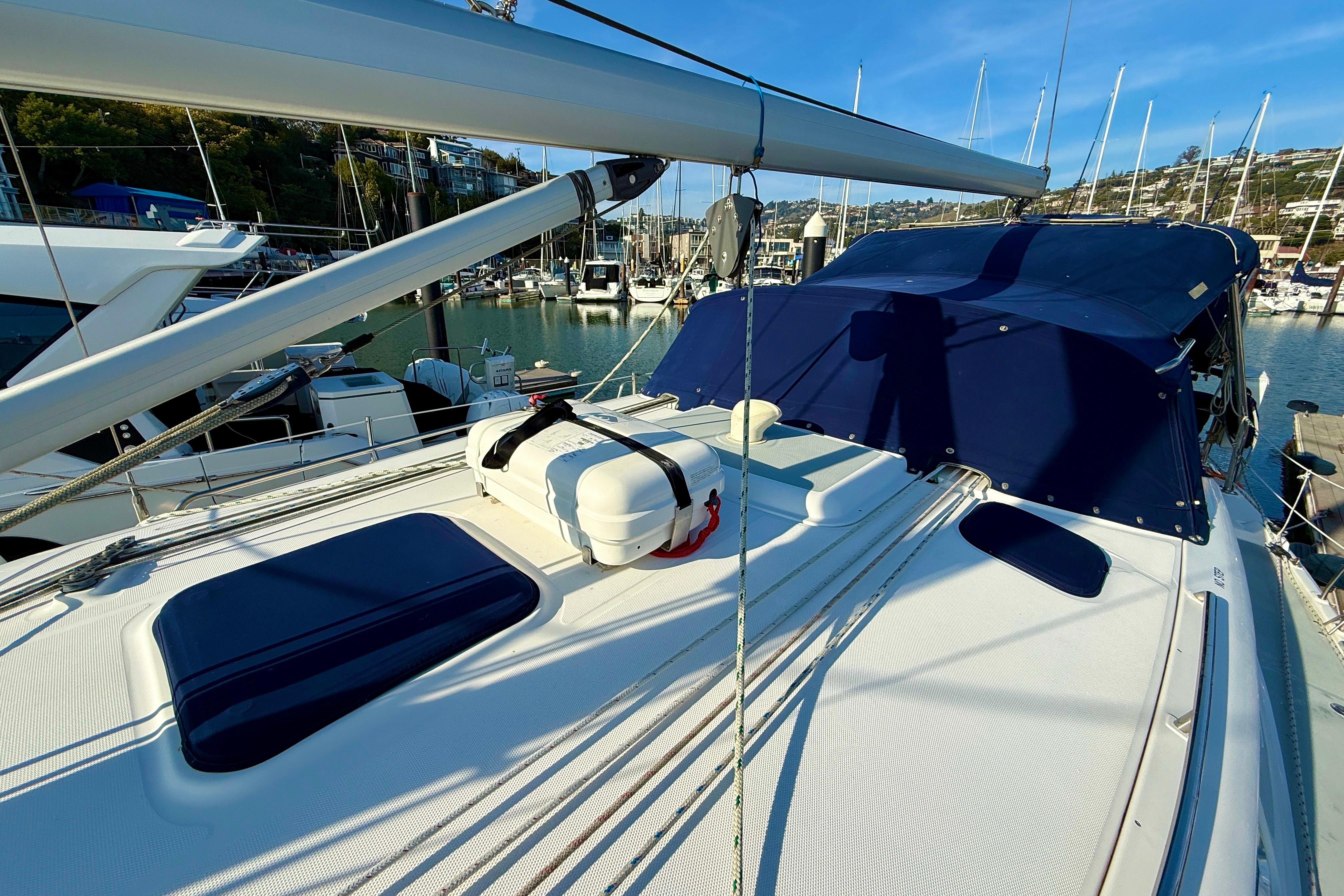 2007 Hunter 44 Deck Salon sailboat docked in a marina, featuring blue covers and rigging.