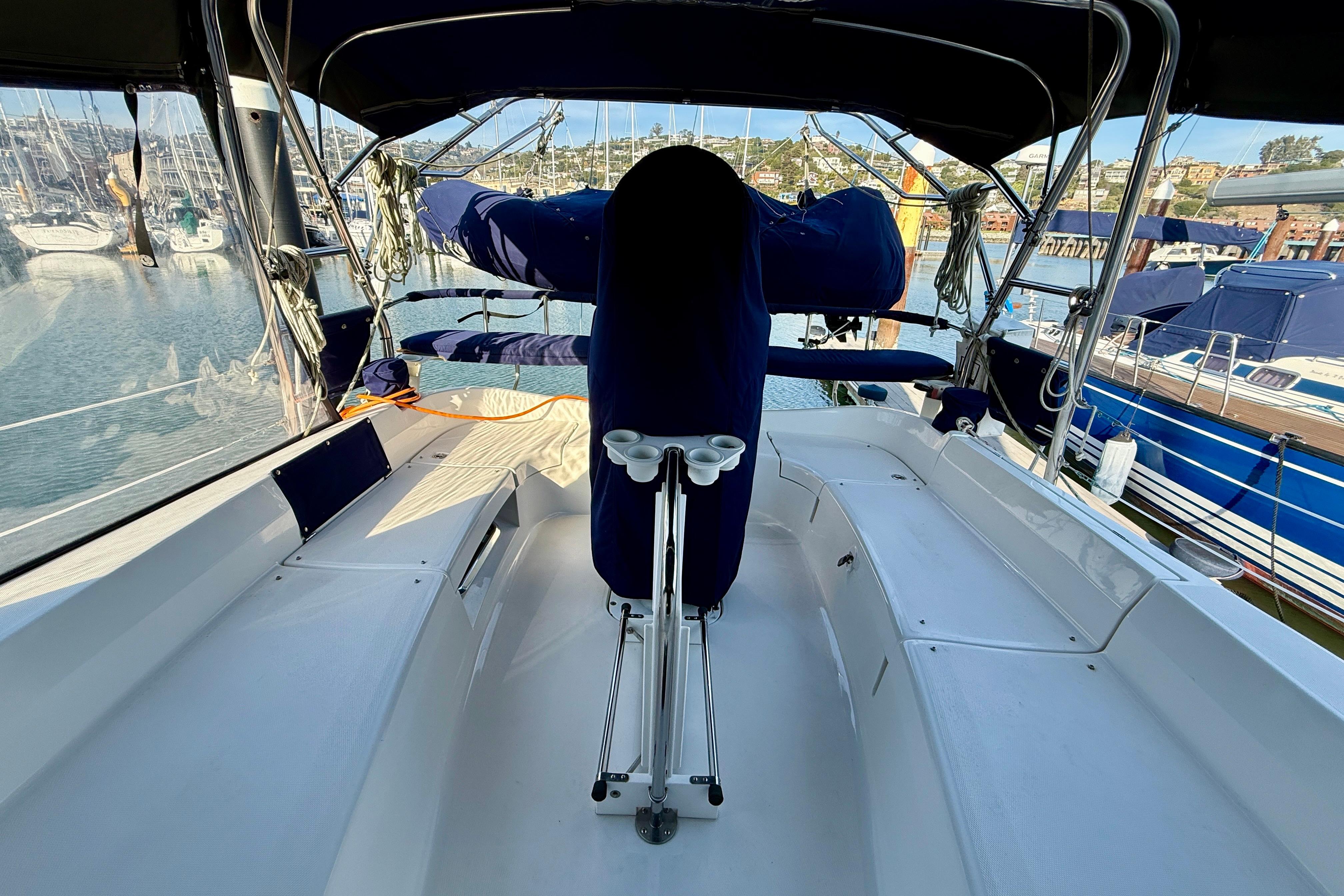 2007 Hunter 44 Deck Salon yacht cockpit with marina view, featuring sleek design and blue covers.