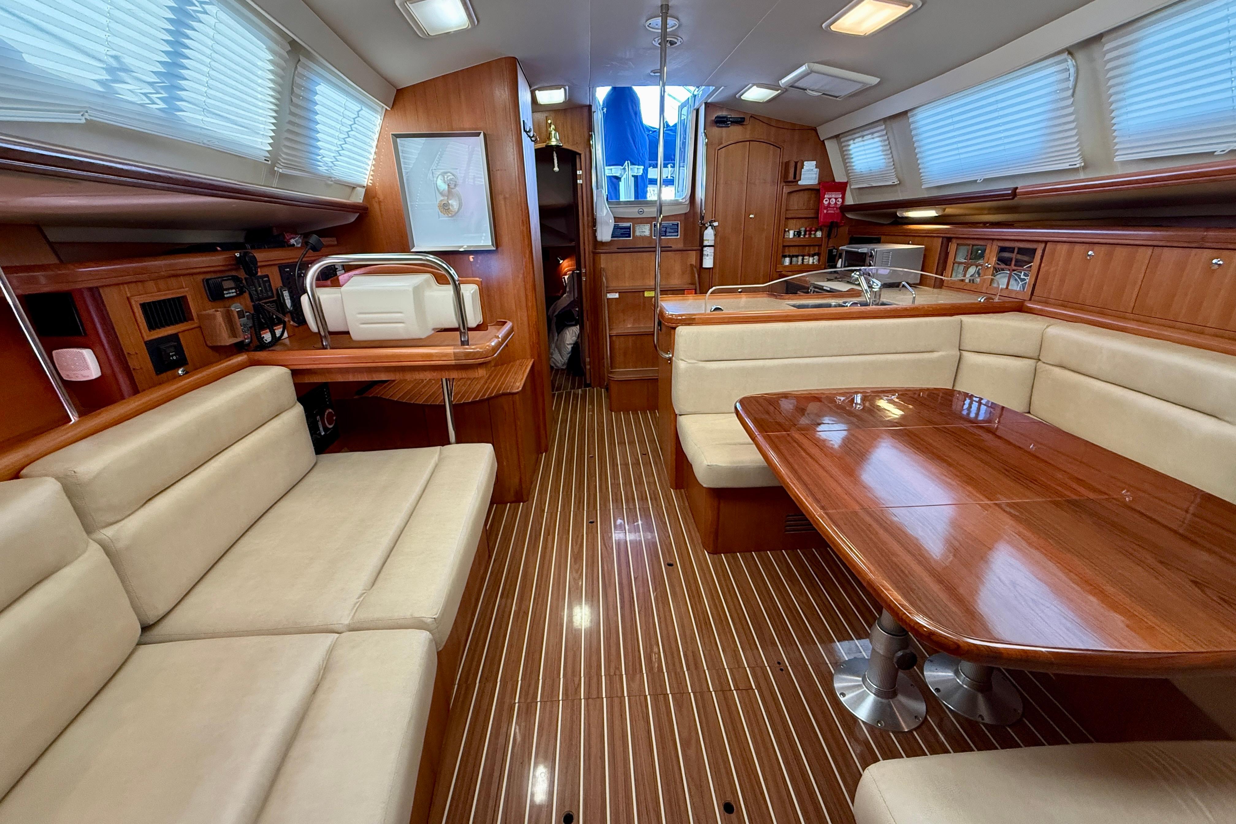 Luxurious interior of 2007 Hunter 44 Deck Salon with elegant wood finishes and plush seating.