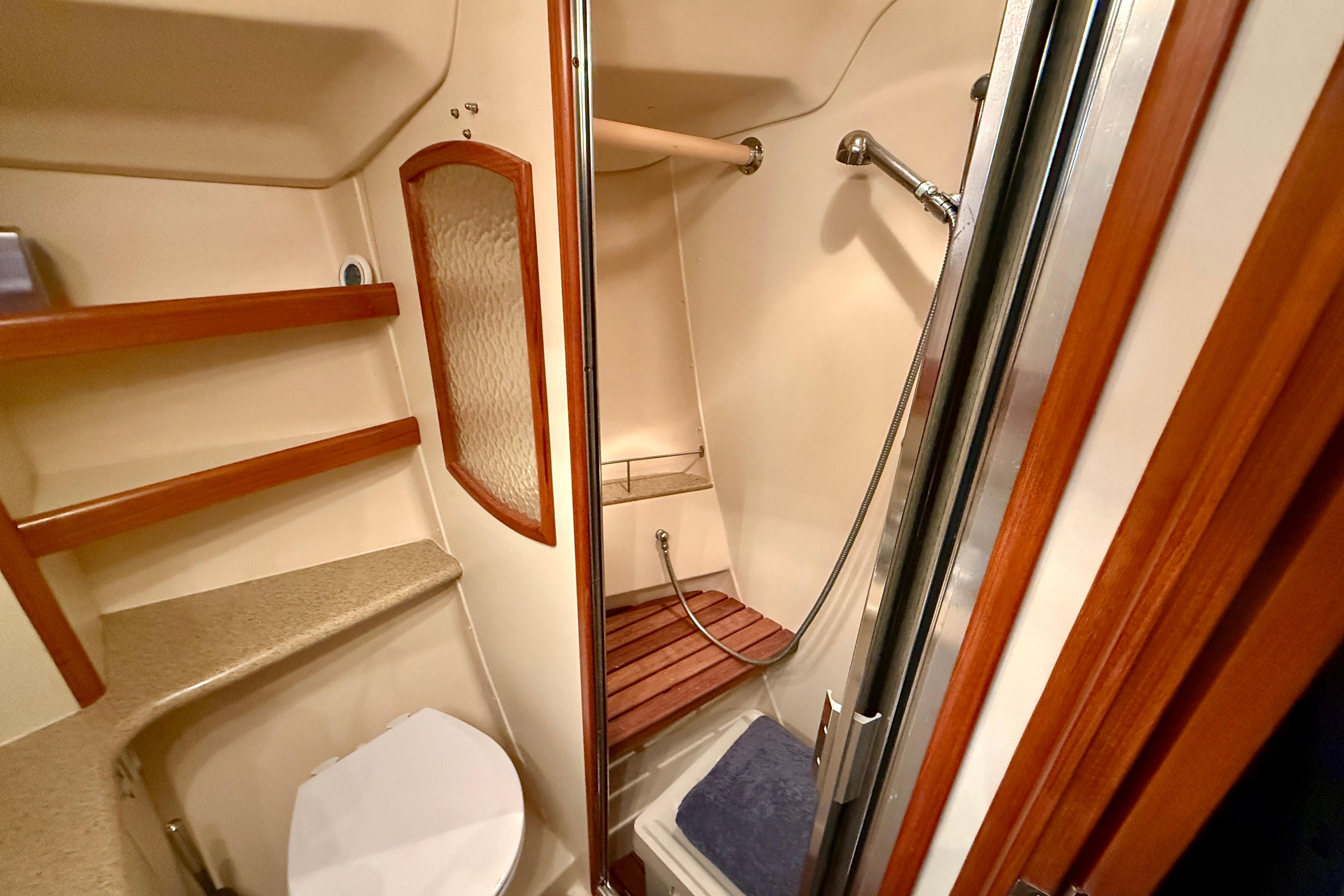 2007 Hunter 44 Deck Salon bathroom with shower, toilet, and wooden shelves.