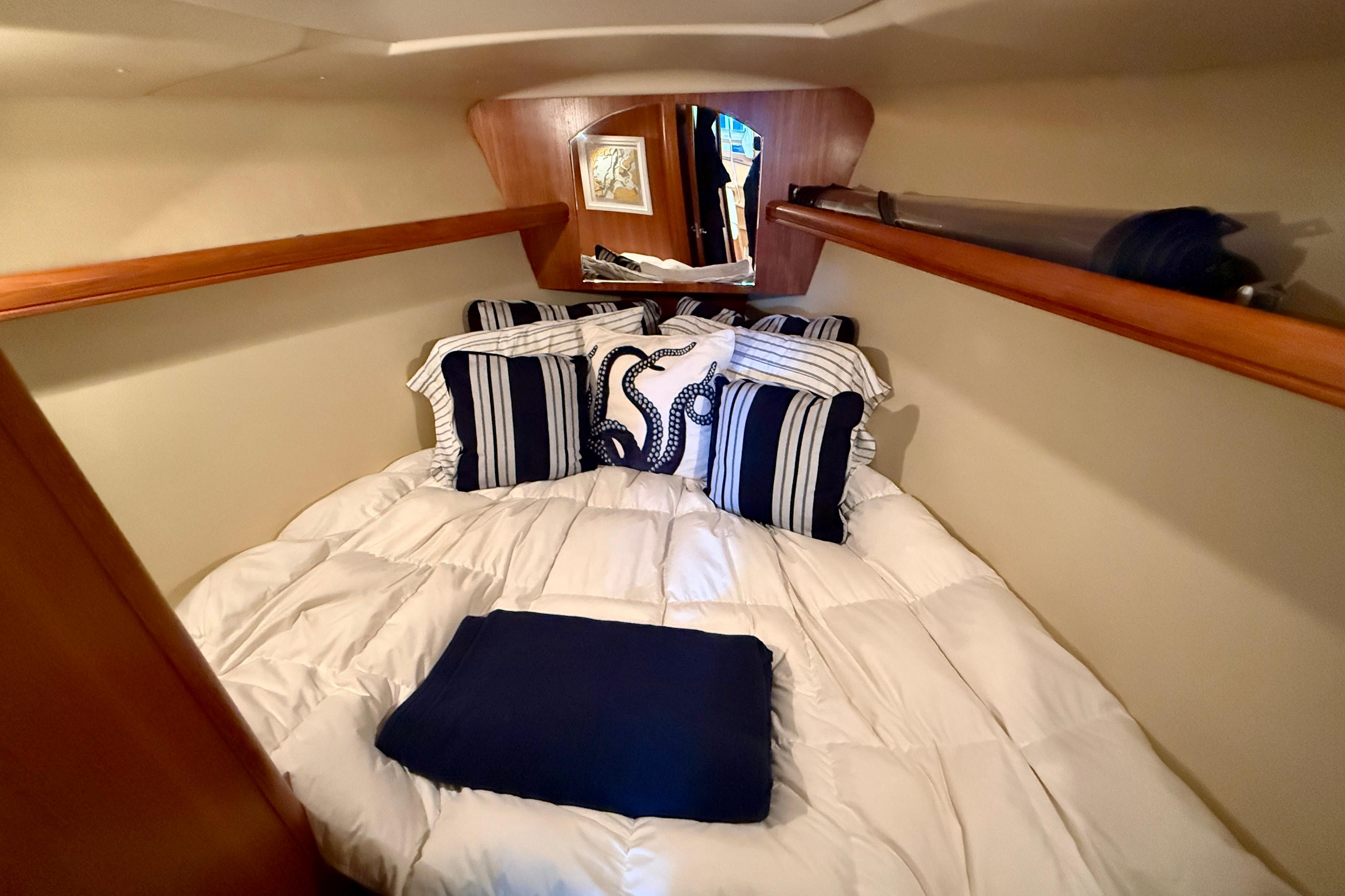 Cozy cabin interior of 2007 Hunter 44 Deck Salon with nautical-themed bedding.