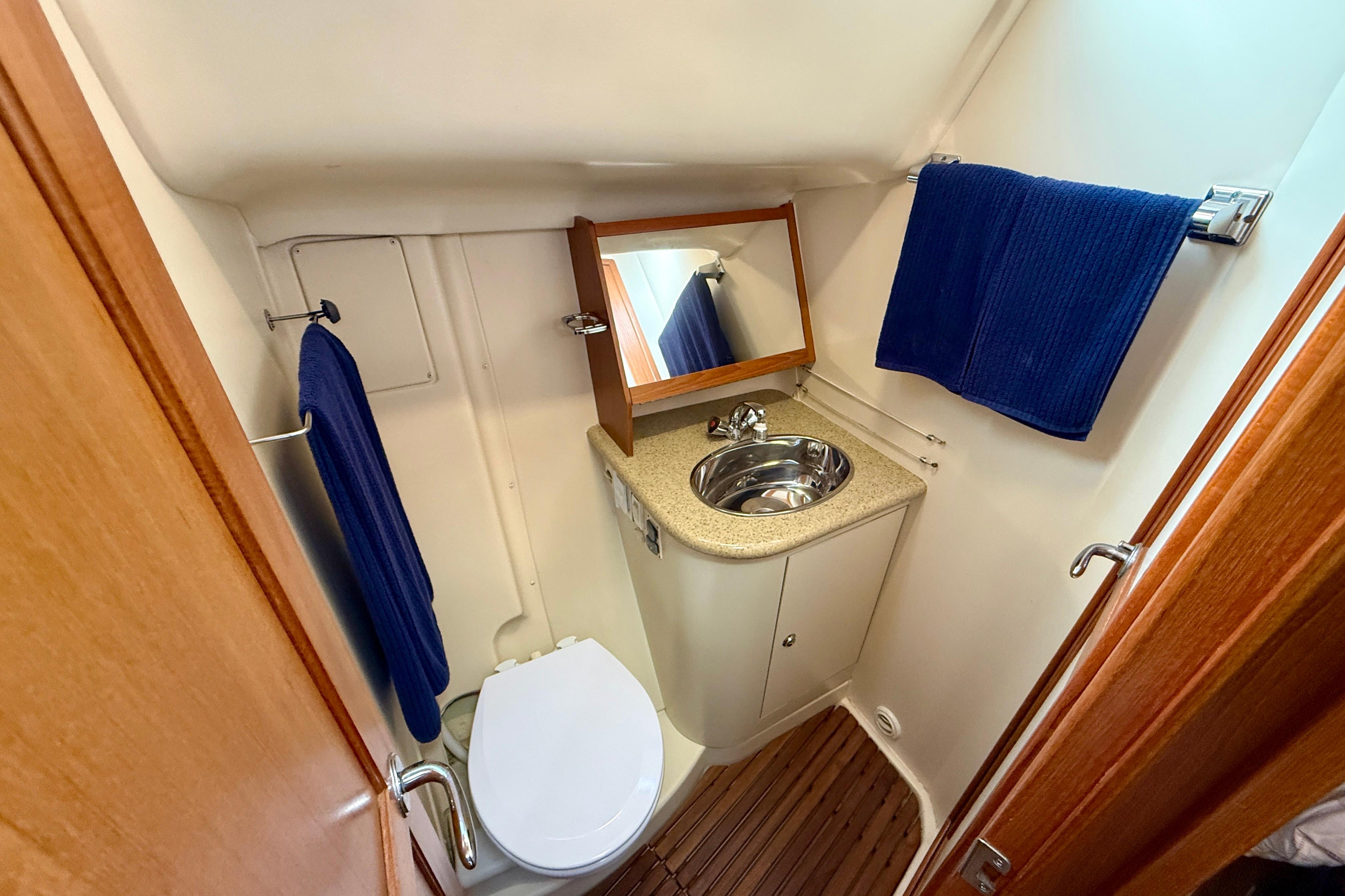 Compact bathroom in 2007 Hunter 44 Deck Salon yacht with sink, toilet, and mirror.