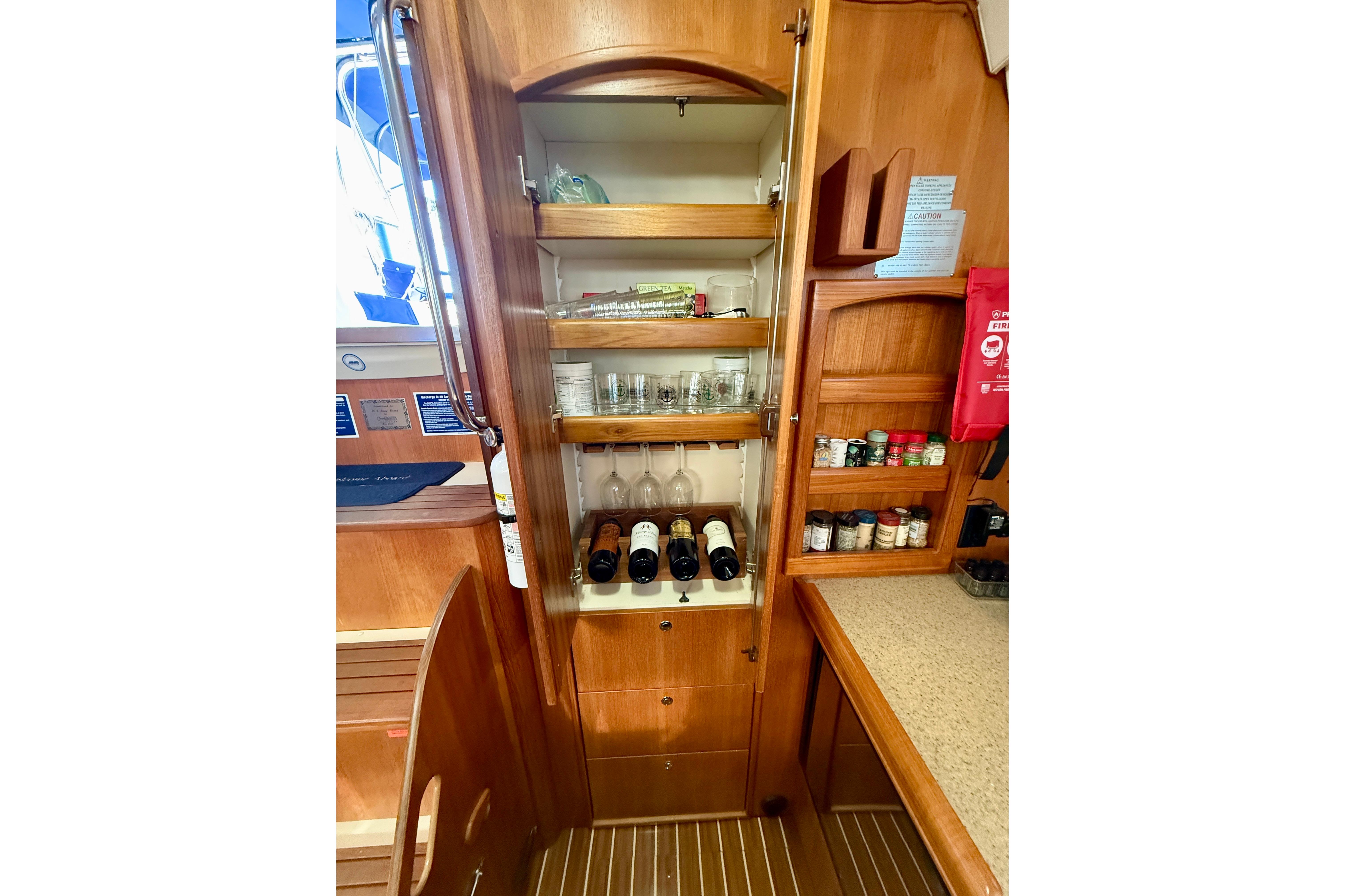 2007 Hunter 44 Deck Salon interior with wooden cabinetry, wine storage, and spice rack.