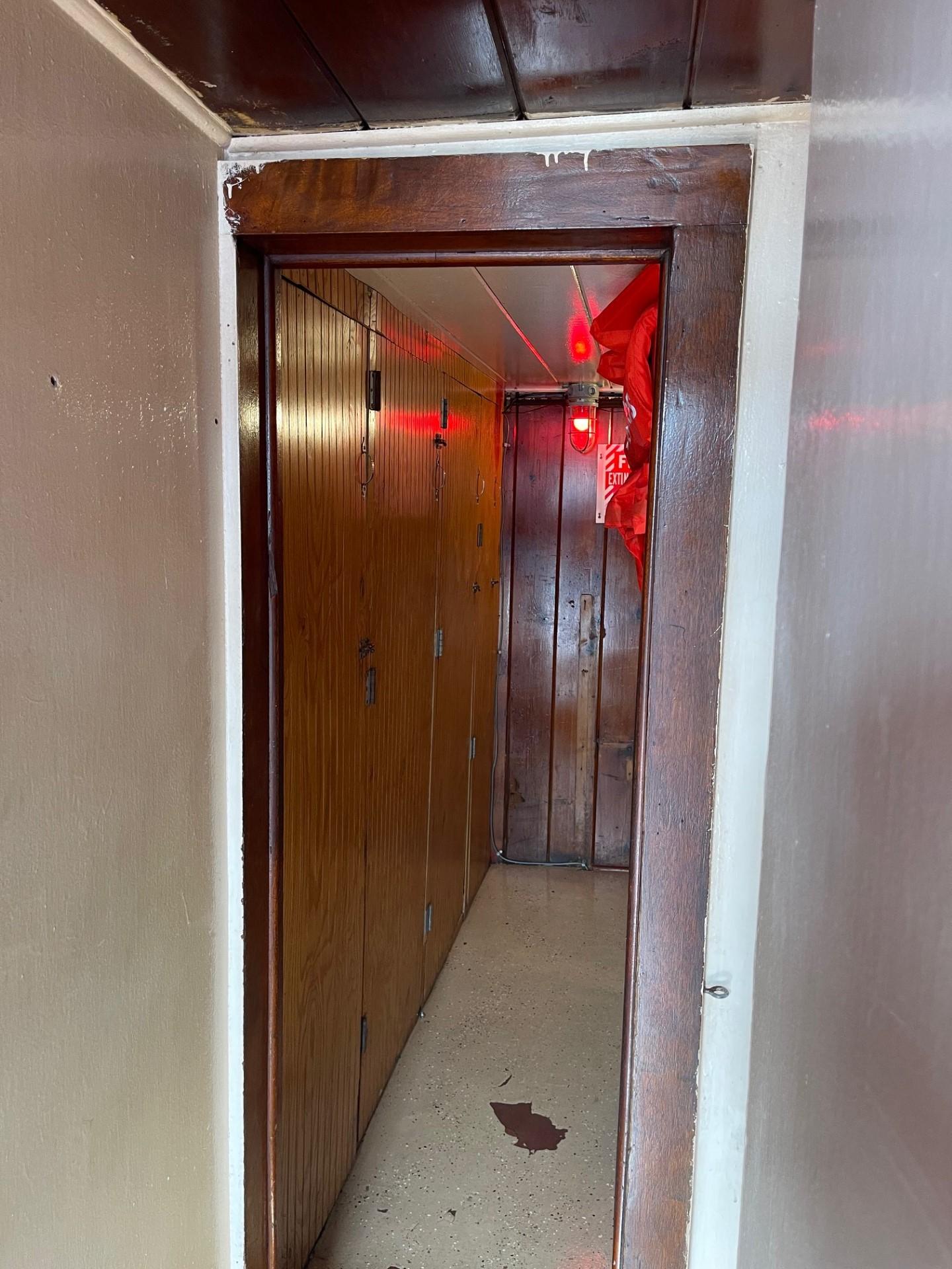 Commercial-Model Bow Tug 1961 -FL-US-Narrow hallway inside a 1961 Commercial Model Bow Tug, featuring wooden paneling and red lighting.-9787034 | Thumbnail