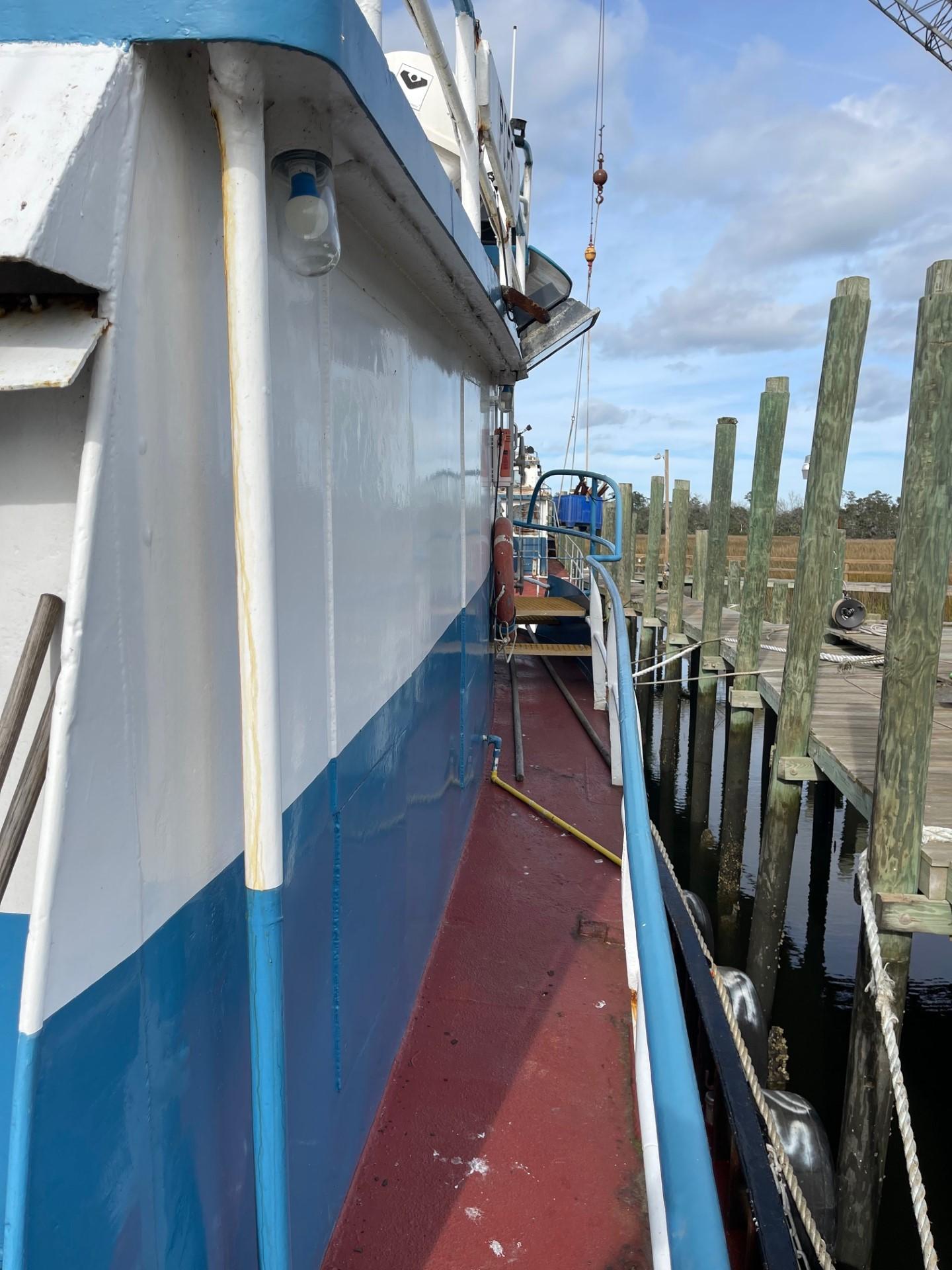 Commercial-Model Bow Tug 1961 -FL-US-1961 Commercial Model Bow Tug docked at a marina, showcasing its side view and vibrant colors.-9787034 | Thumbnail