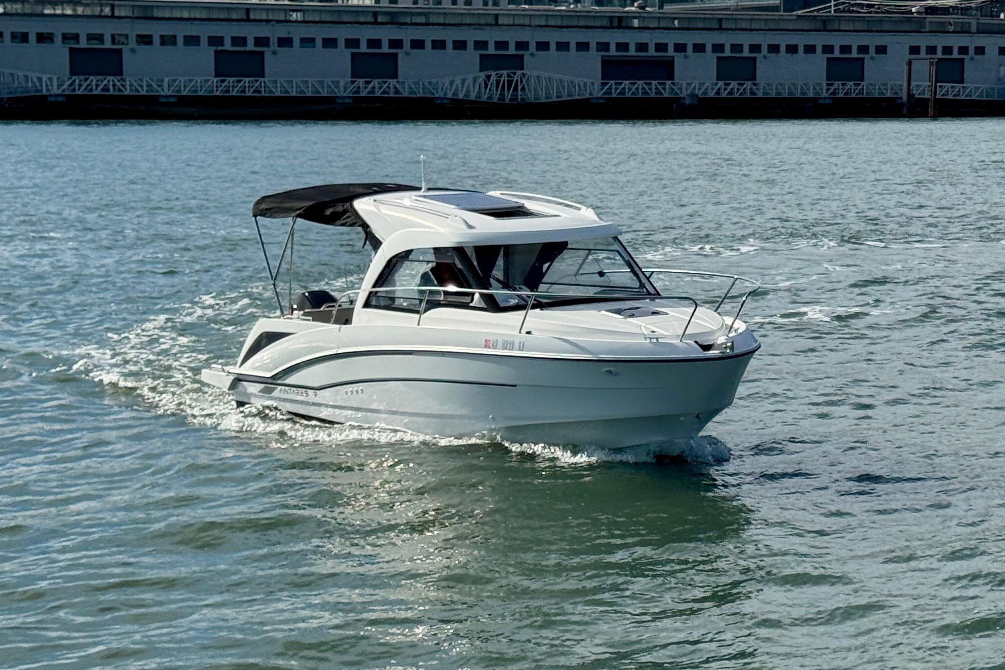 2022 Beneteau Antares 7 cruising on water near a dock.