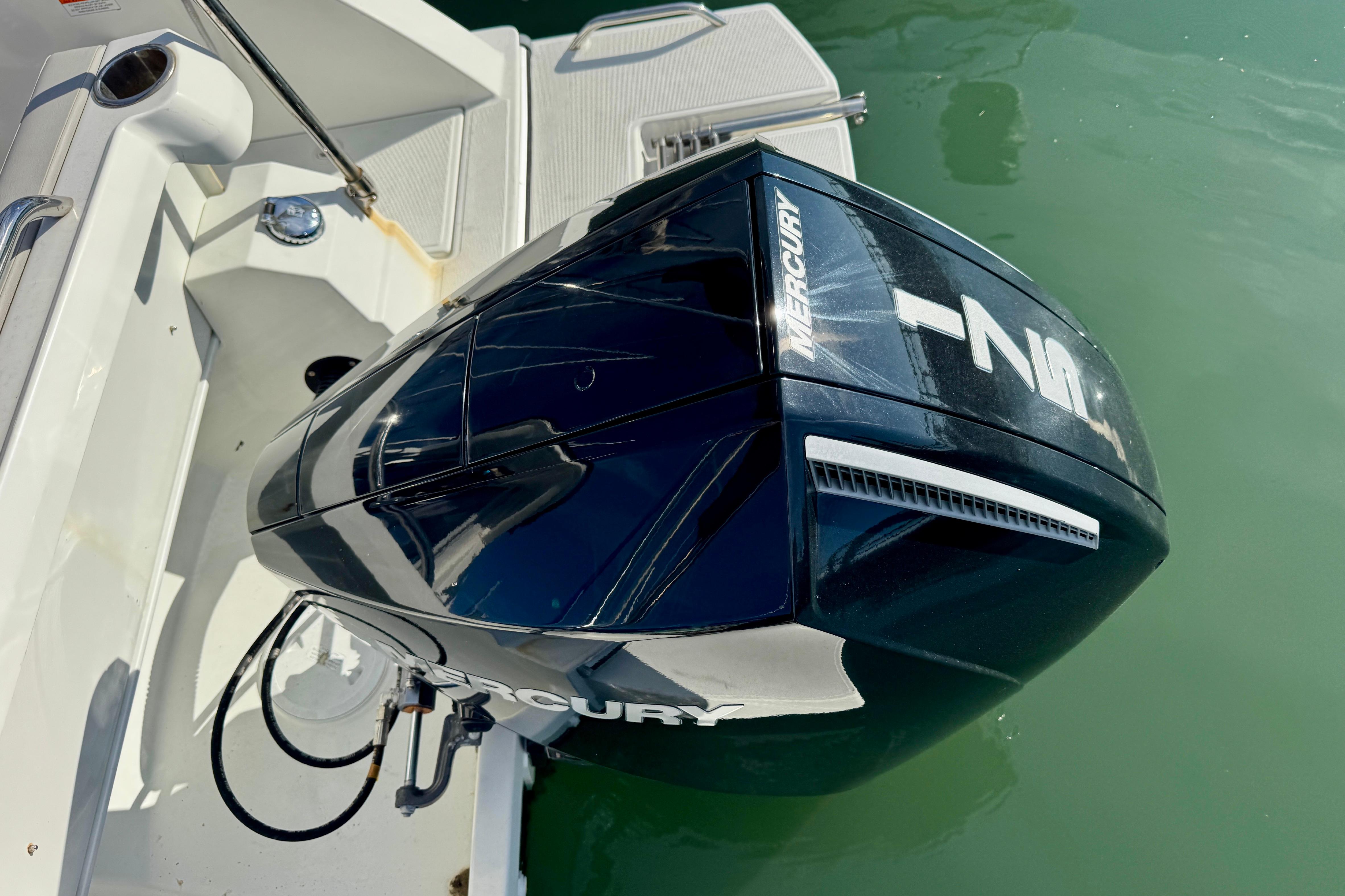 Outboard motor on 2022 Beneteau Antares 7 boat, docked in clear water.