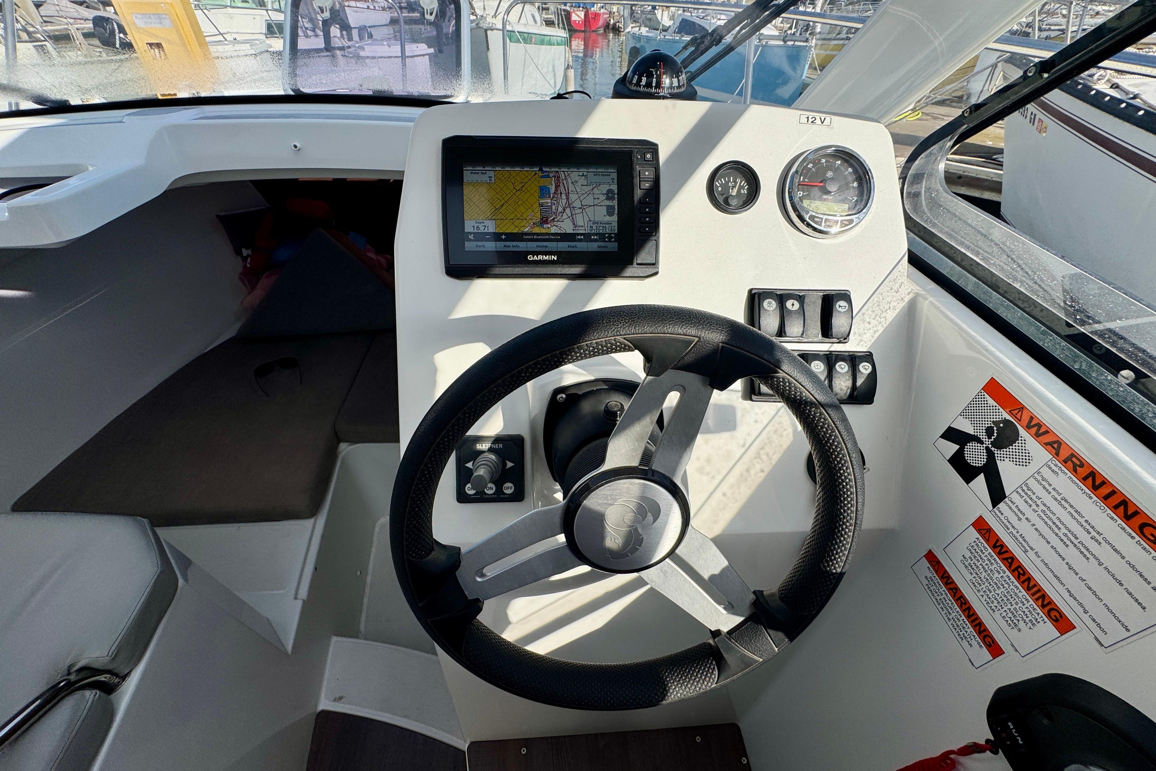 Cockpit of 2022 Beneteau Antares 7 with steering wheel and navigation display.