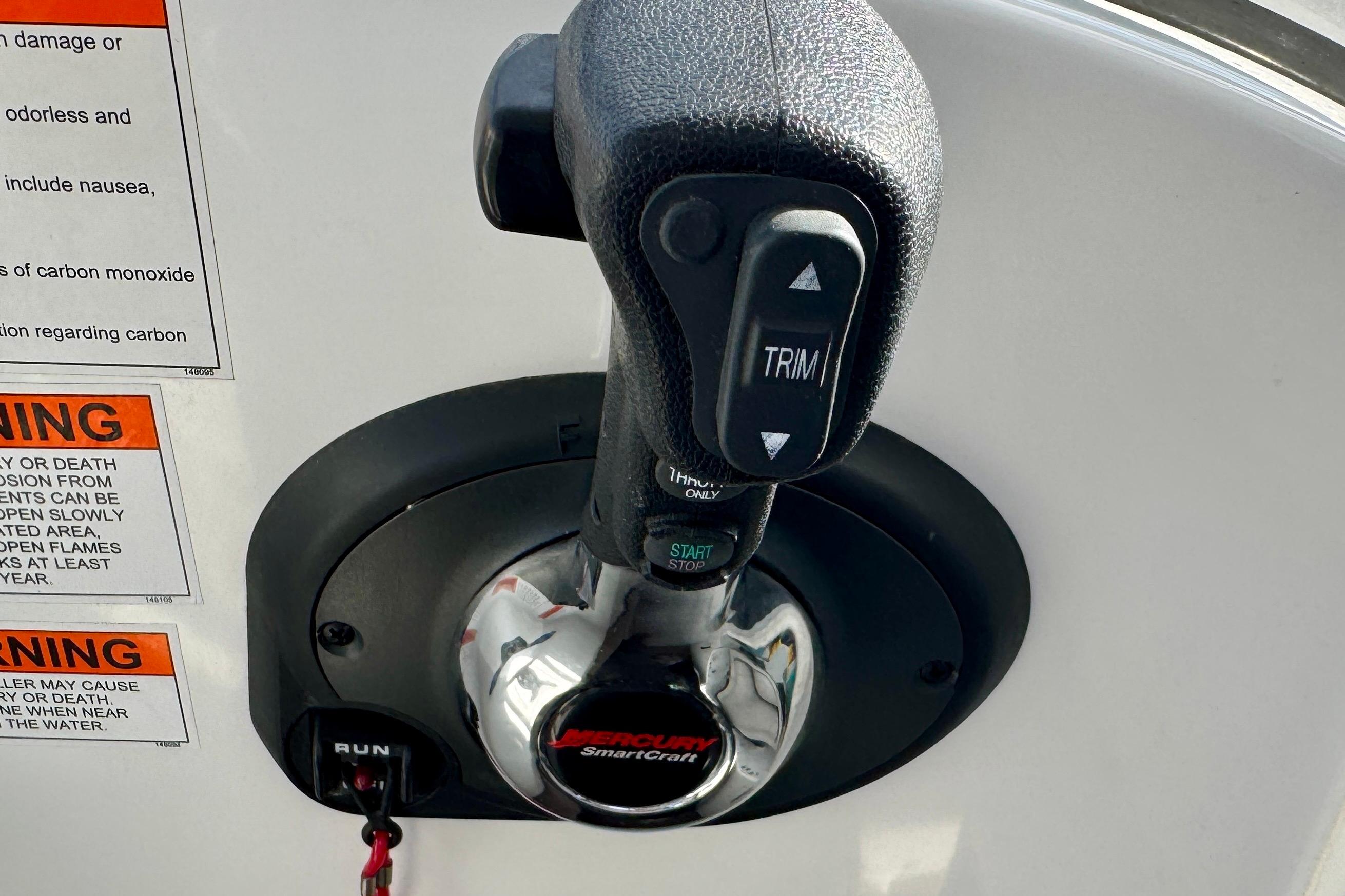 Throttle control of 2022 Beneteau Antares 7 boat with warning labels visible.