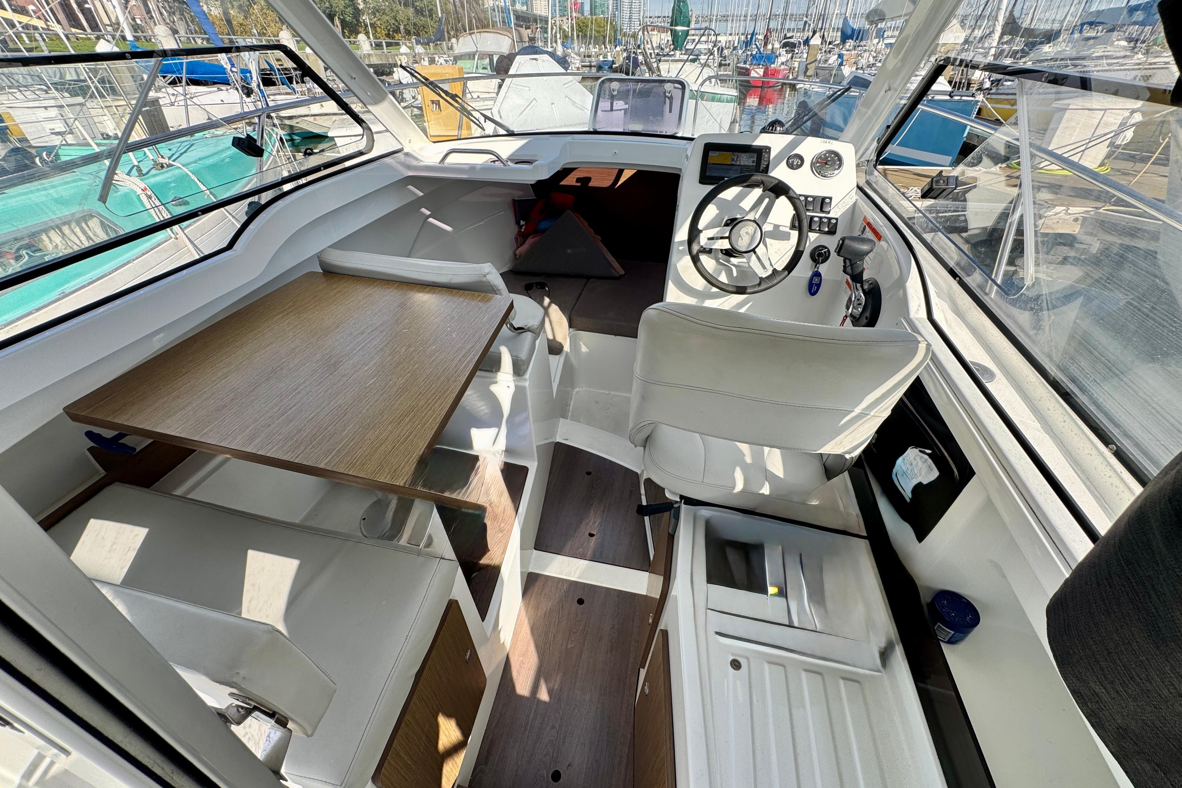 Interior of 2022 Beneteau Antares 7 boat, featuring helm, seating, and table.