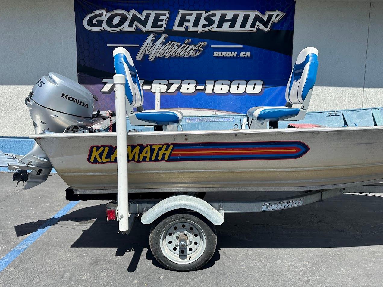 1998 Klamath 14 DLX boat with Honda motor on trailer, displayed at Gone Fishin' Marine.