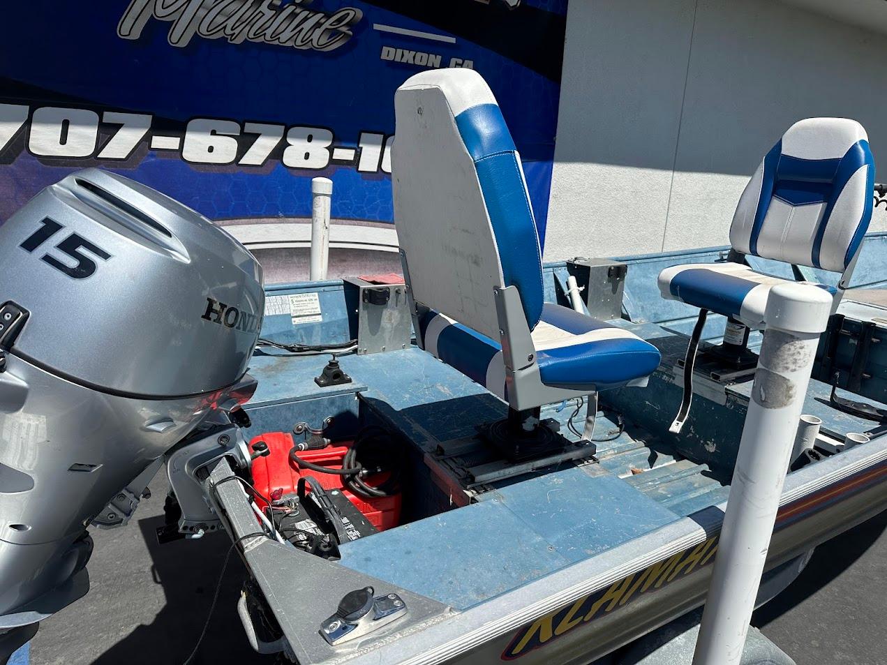 1998 Klamath 14 DLX boat with Honda 15 outboard motor and blue seats.