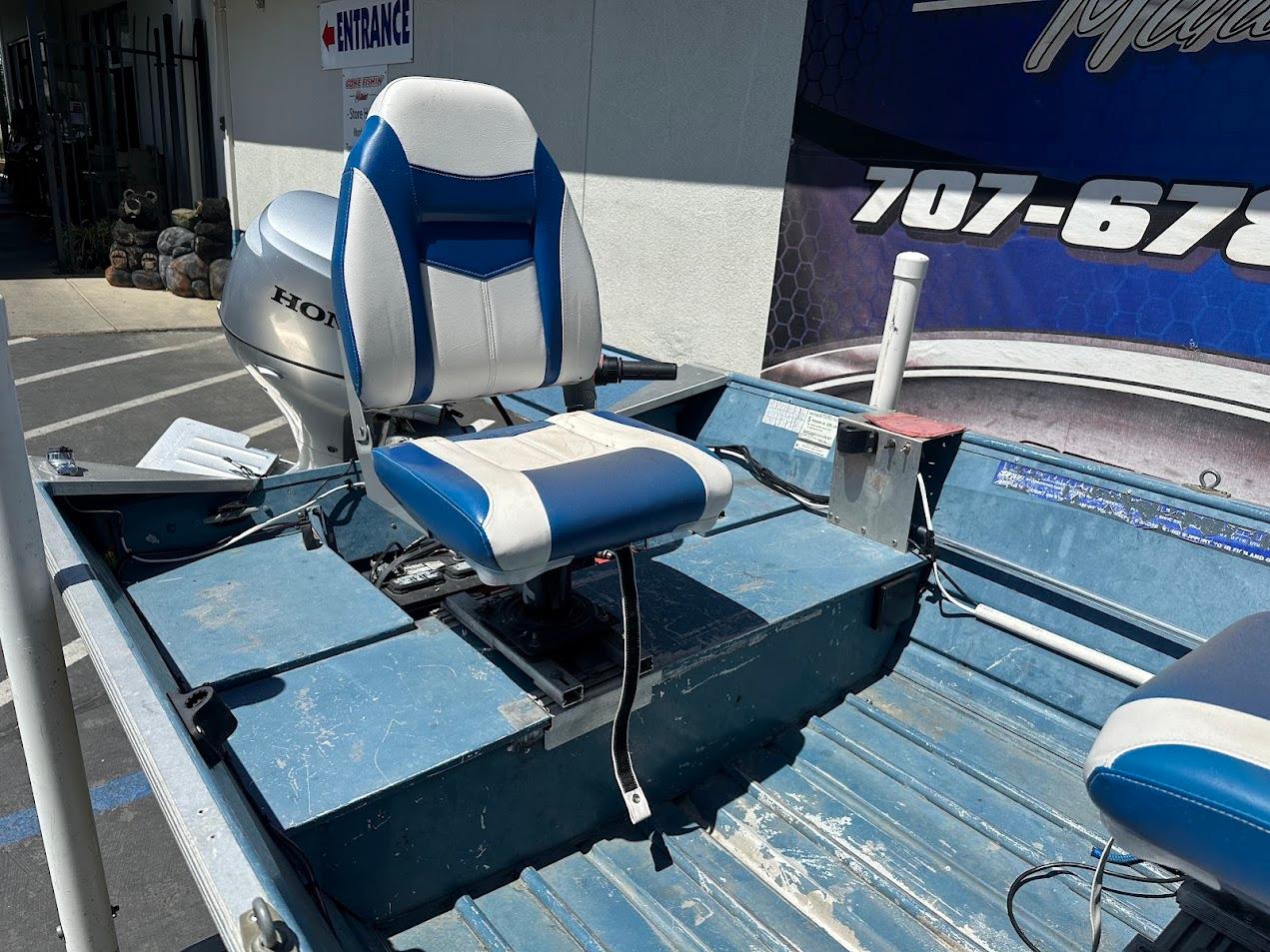 1998 Klamath 14 DLX boat with blue and white seating and Honda outboard motor.