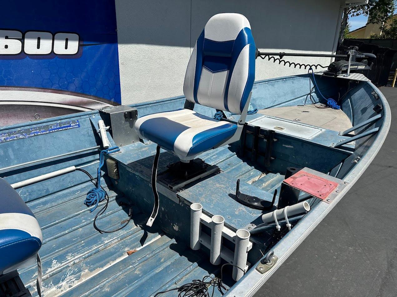 1998 Klamath 14 DLX boat interior with blue and white seating and fishing rod holders.