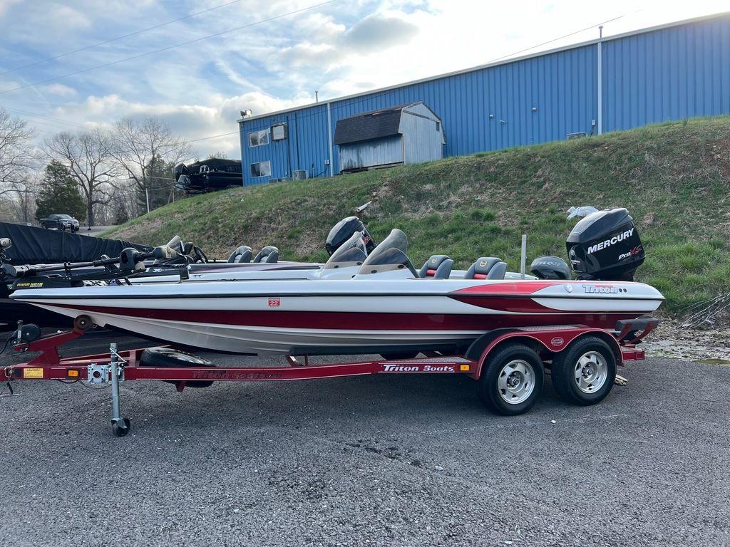 1999 Triton TR20 boat on trailer with Mercury engine, parked outdoors.