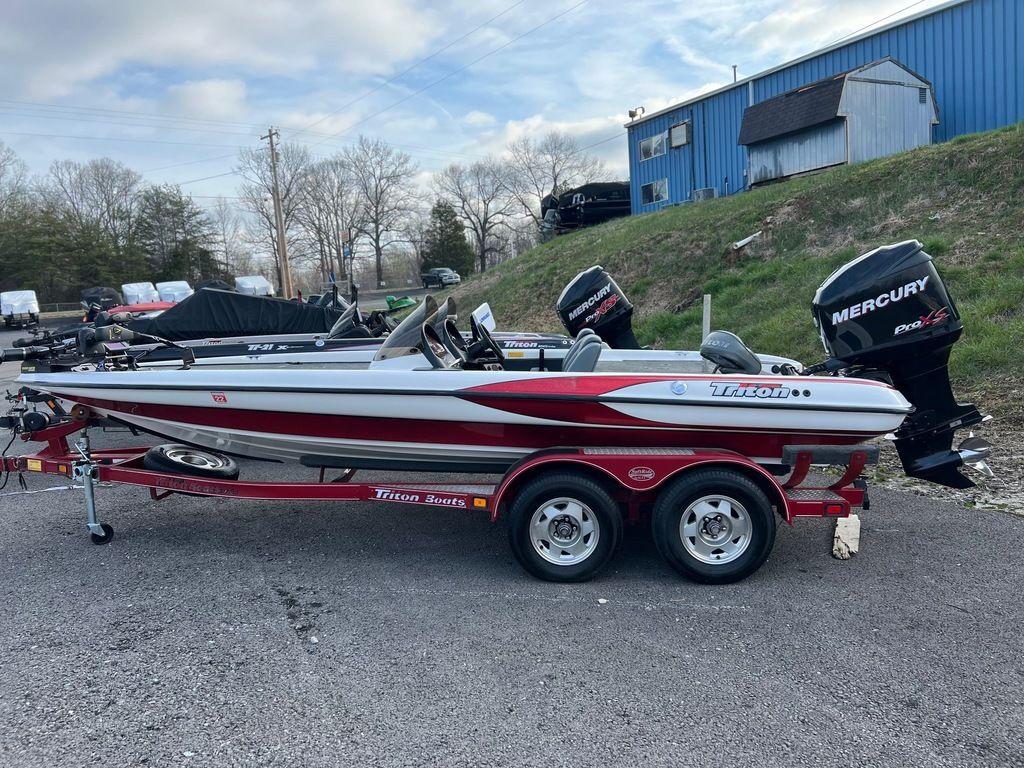 1999 Triton TR20 boat on trailer with Mercury outboard motor, parked outdoors.