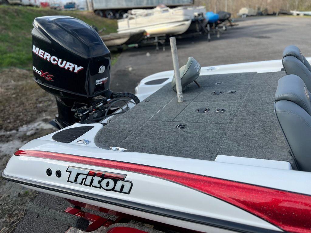 1999 Triton TR20 boat with Mercury Pro XS engine, docked outdoors.