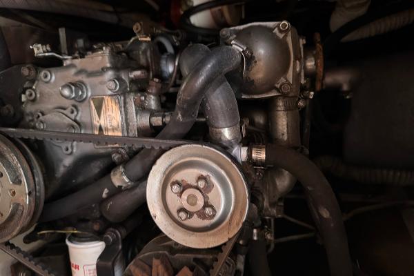 Engine of a 1984 Endeavour 38 sailboat, showcasing belts and hoses.