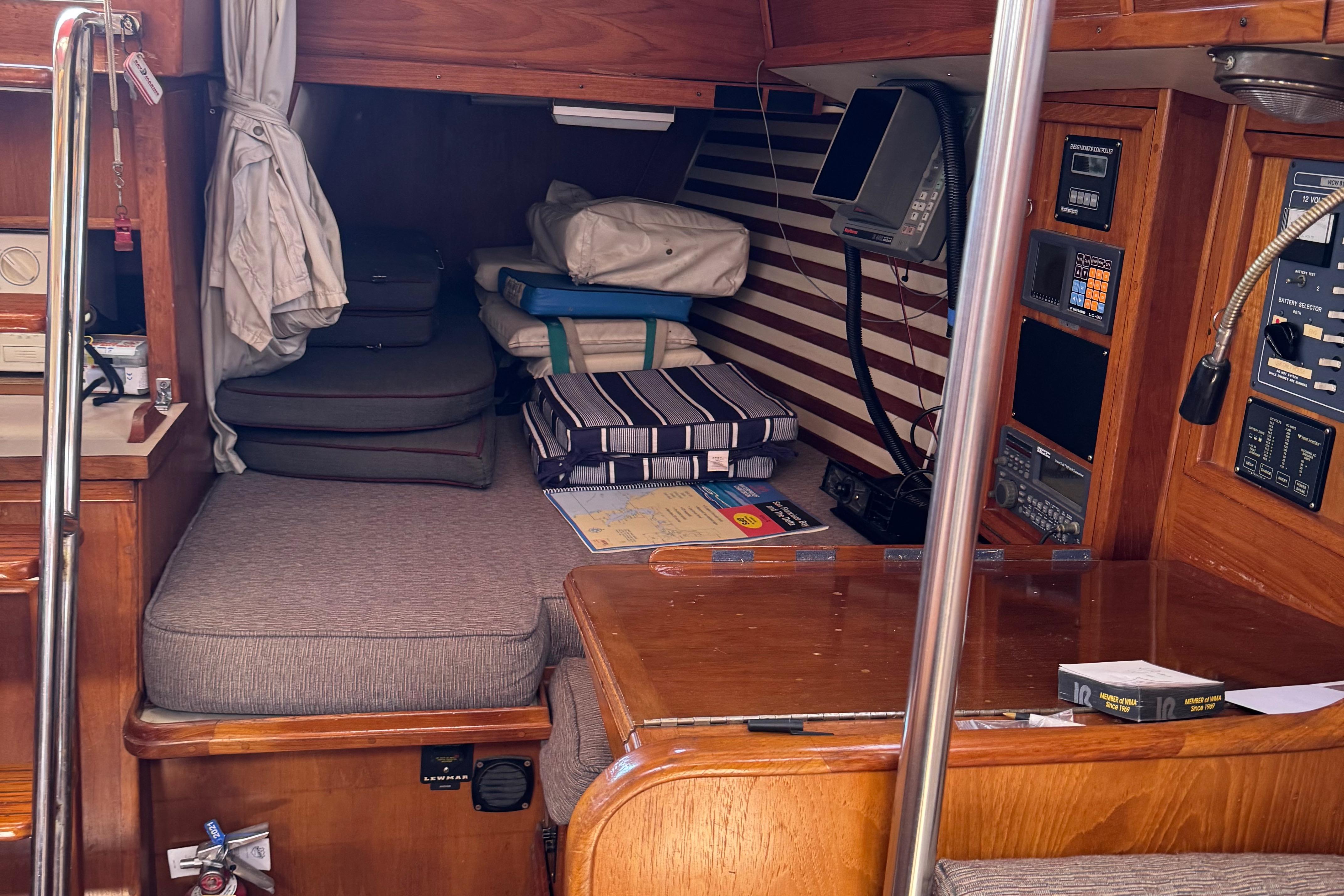 Interior of 1984 Endeavour 38 sailboat with navigation equipment and cozy seating area.