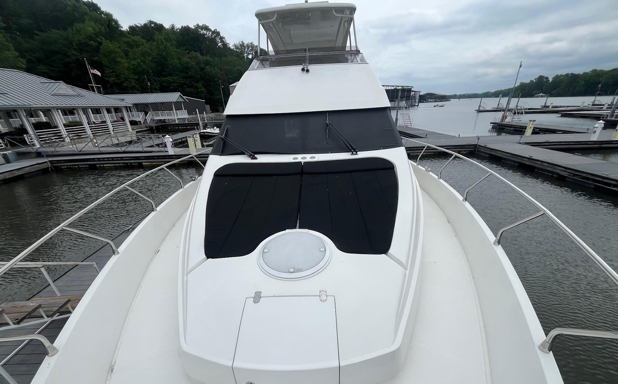 Marquis-59 2004 -IL-US-2004 Marquis 59 yacht docked at a marina, surrounded by calm waters and lush greenery.-9798156 | Thumbnail