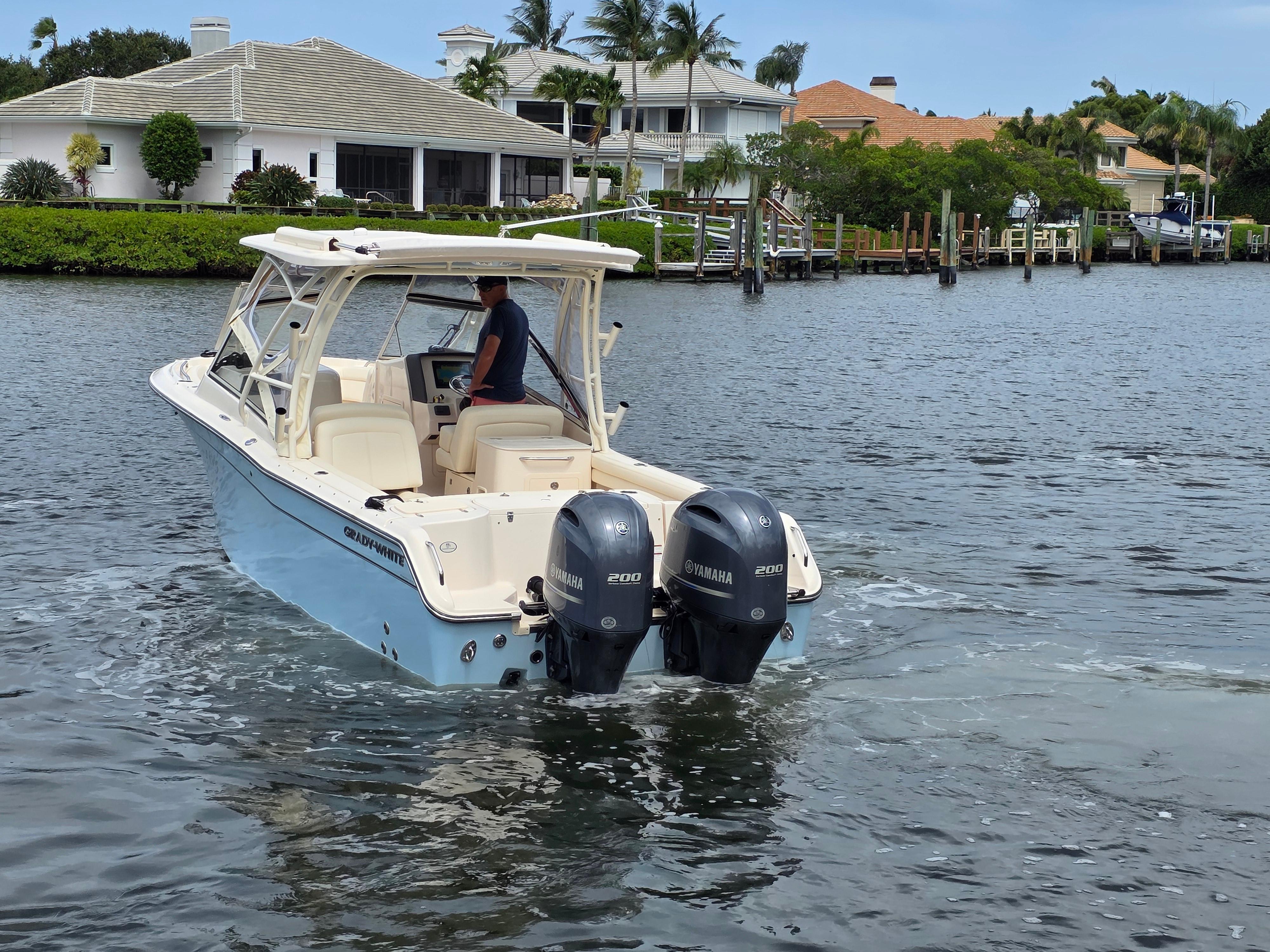 2023 Grady-White Freedom 275 boat cruising on a scenic waterfront.