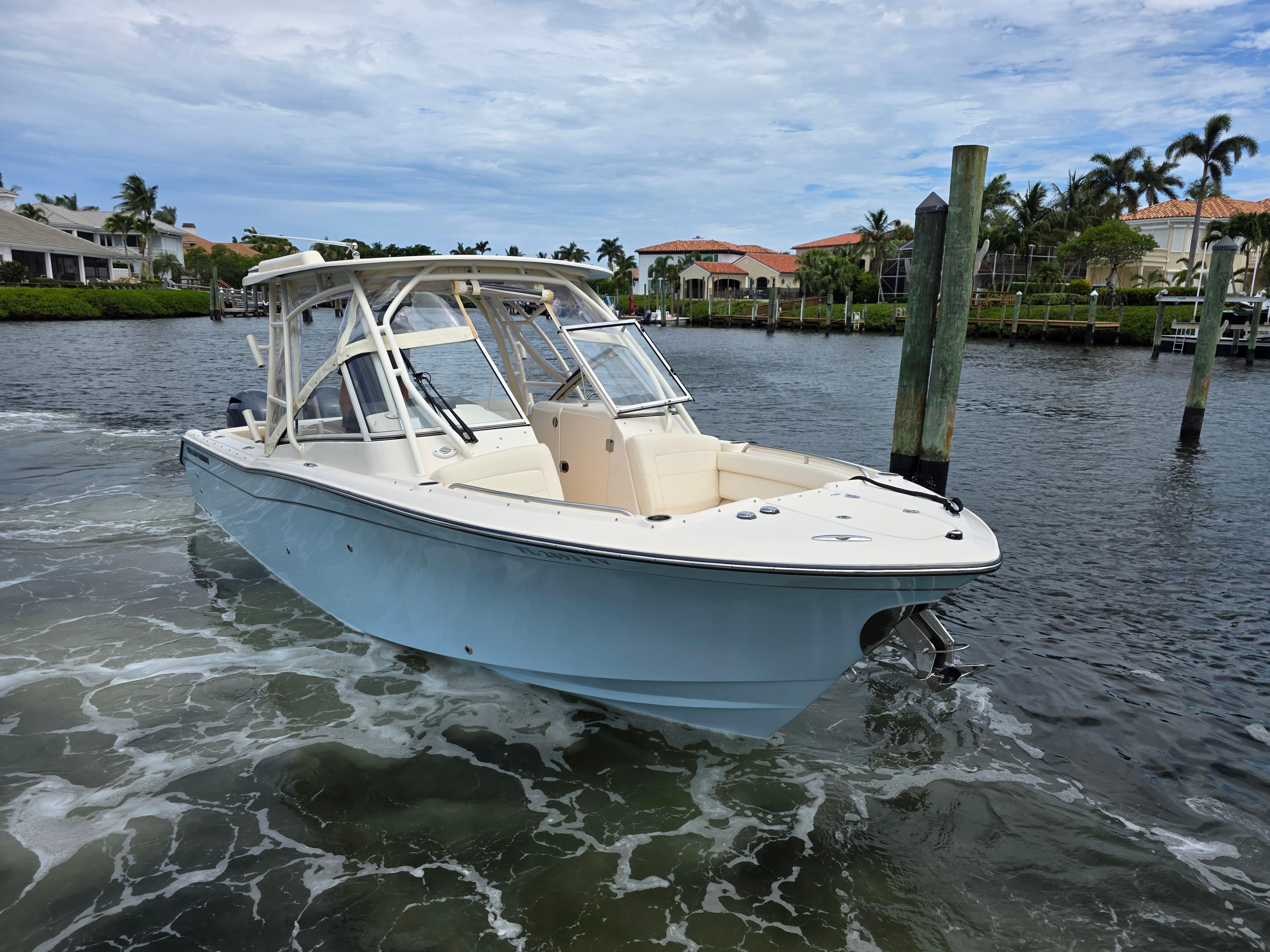 2023 Grady-White Freedom 275 boat on water, near waterfront homes and palm trees.