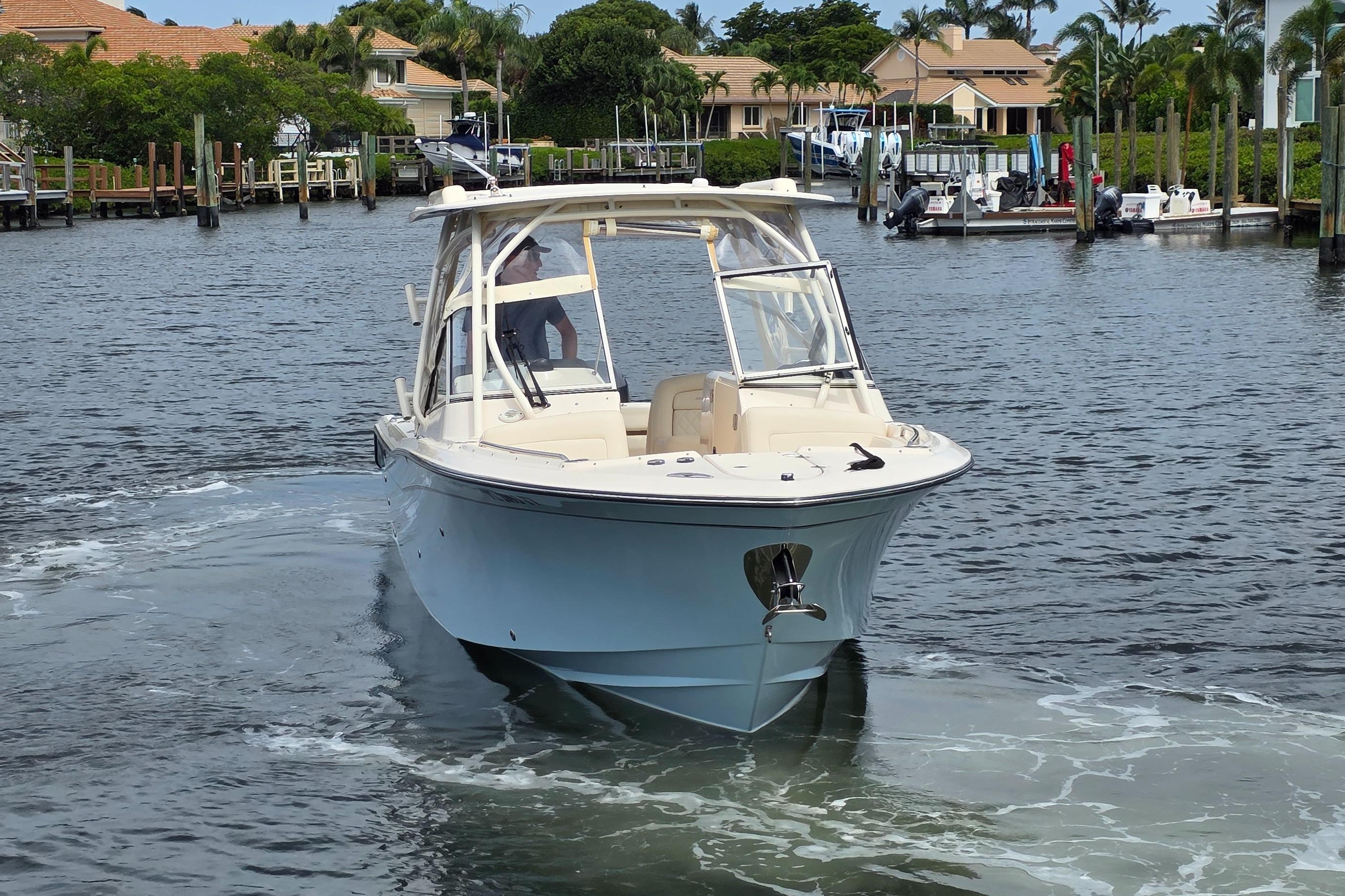 2023 Grady-White Freedom 275 boat cruising in a scenic marina setting.