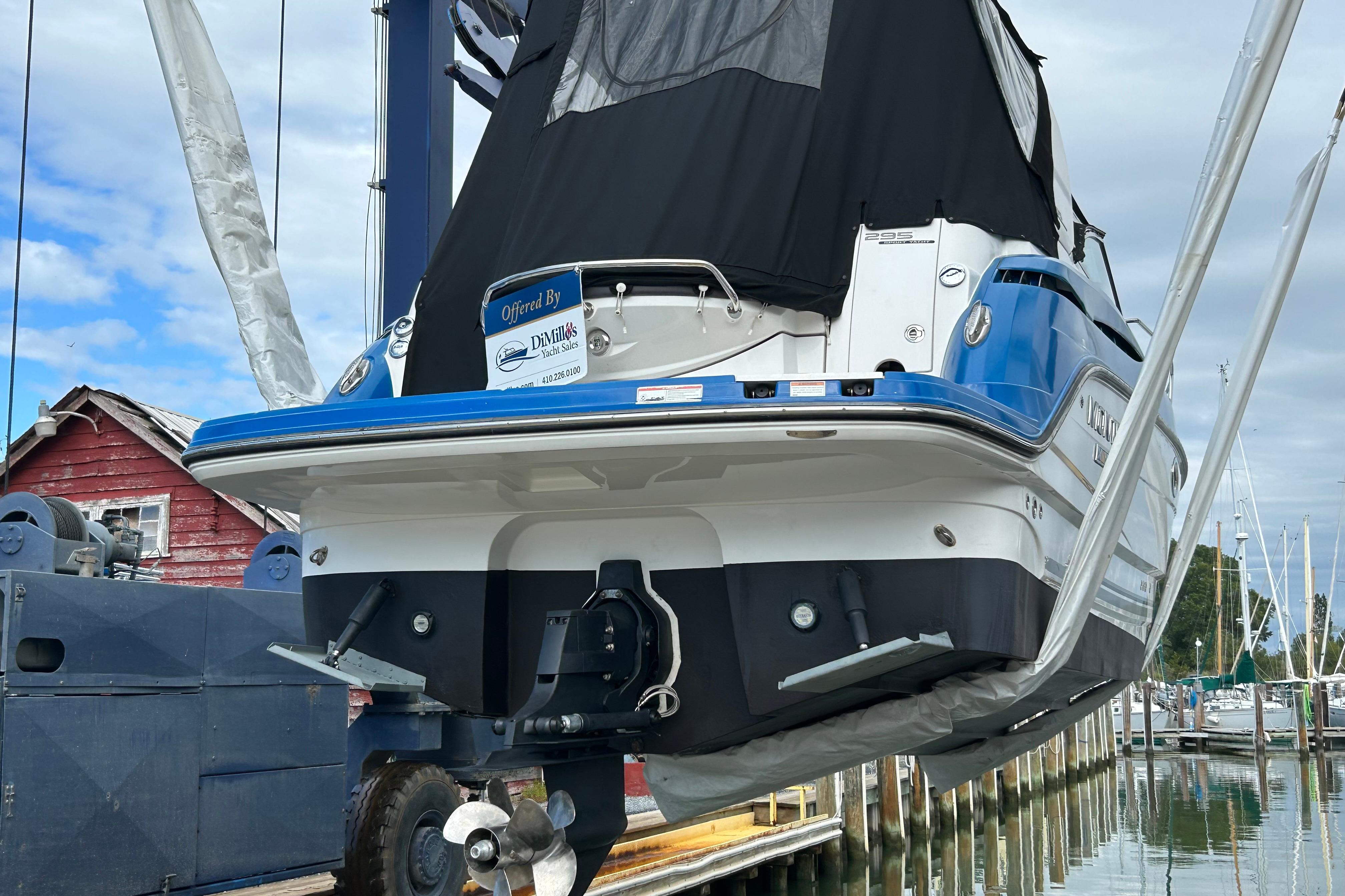 2019 Monterey 295 Sport Yacht in marina, rear view, blue and white hull.