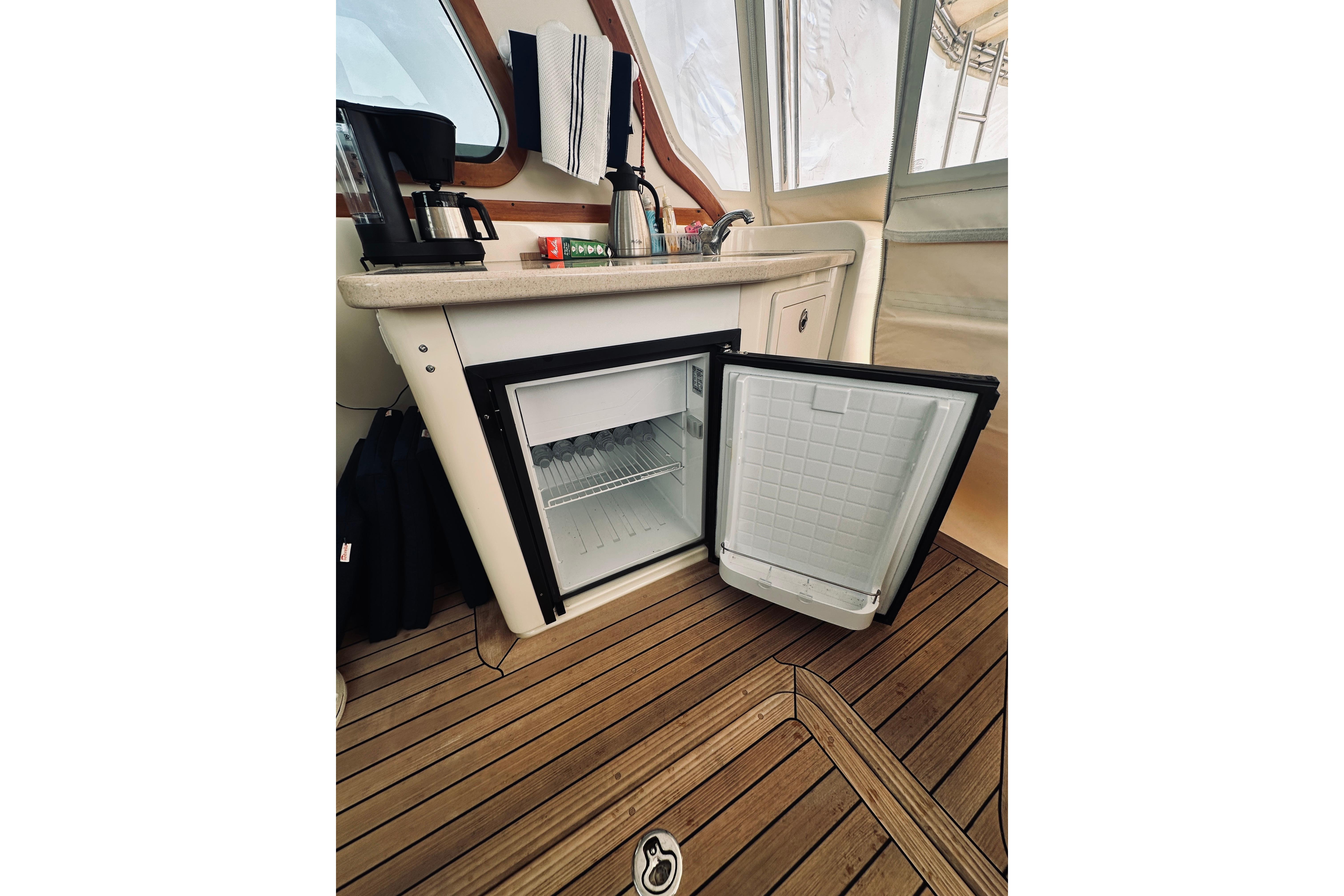 2008 Sabre 38 Hard Top Express interior with open mini fridge and wooden flooring.