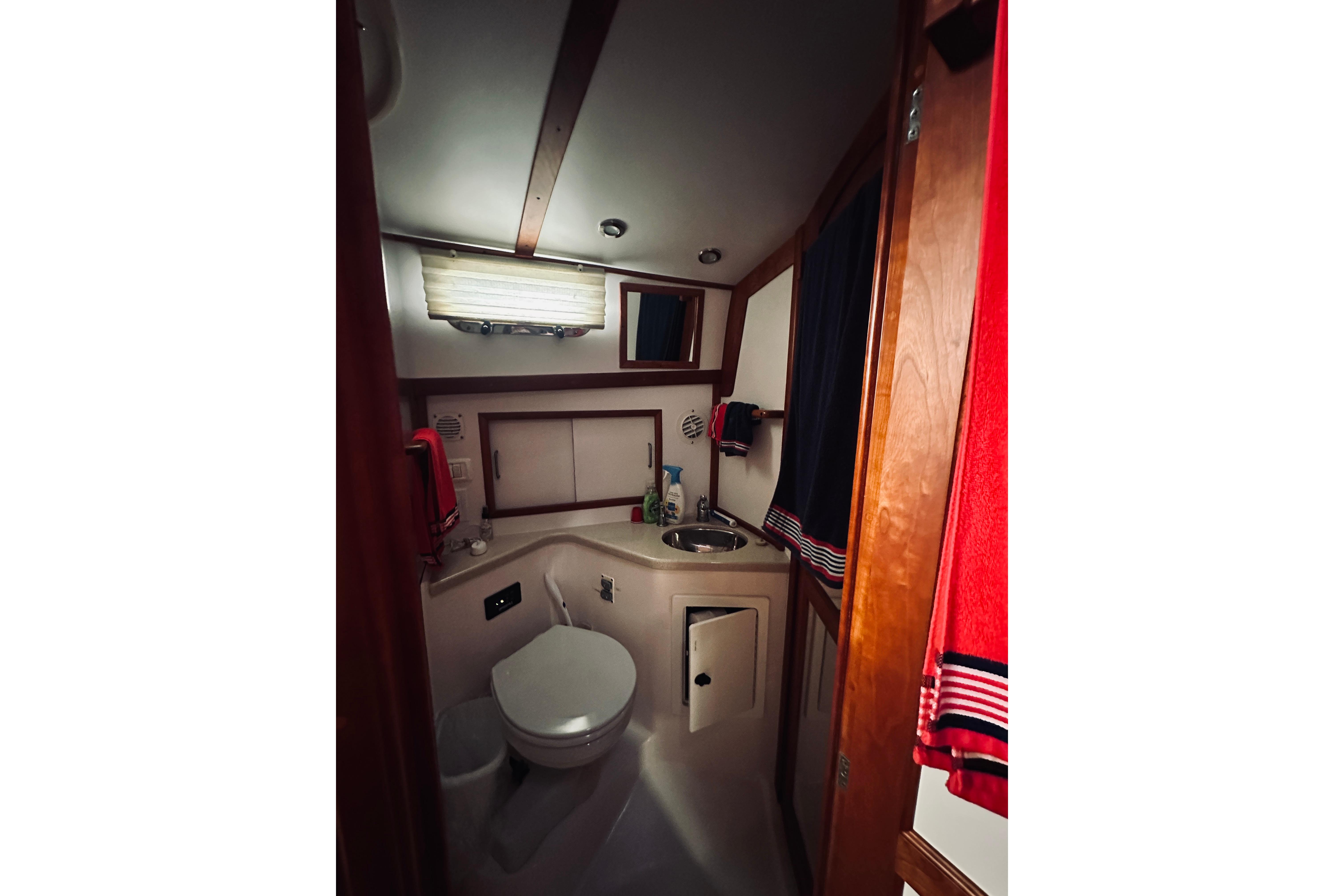 2008 Sabre 38 Hard Top Express bathroom with sink, toilet, and wooden cabinetry.