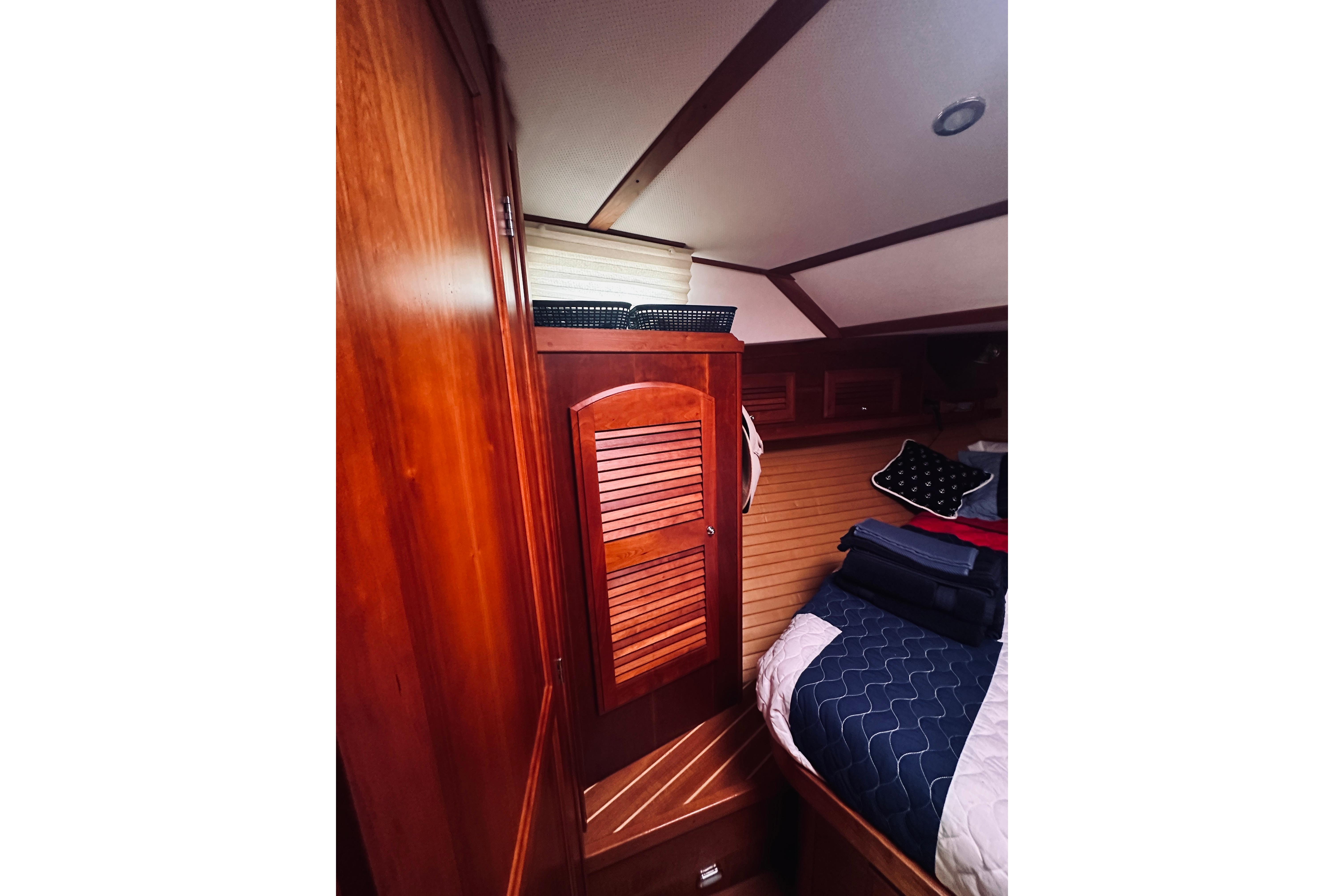 Interior cabin of 2008 Sabre 38 Hard Top Express with wooden cabinetry and cozy bedding.