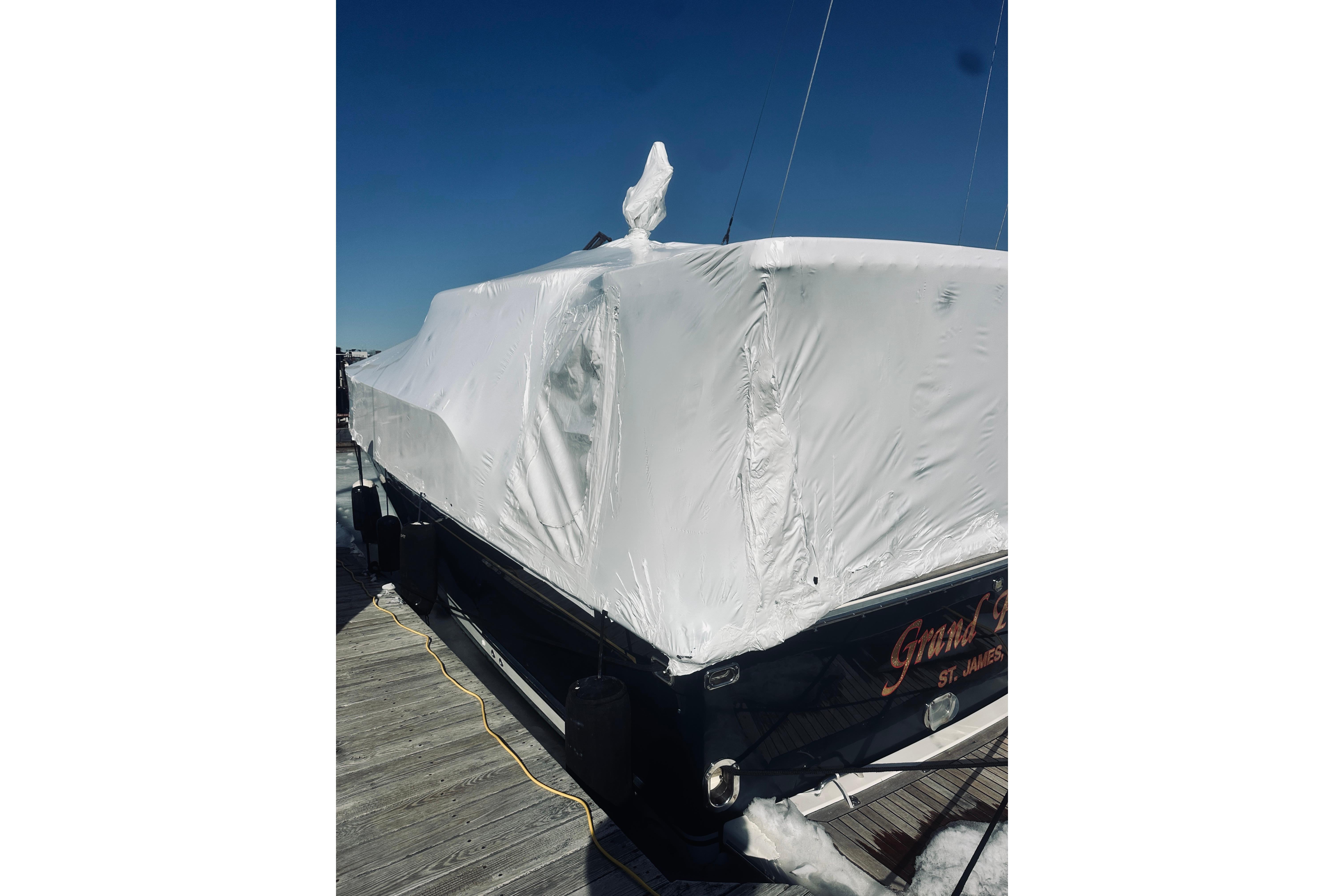 2008 Sabre 38 Hard Top Express boat covered in protective wrap at dock.