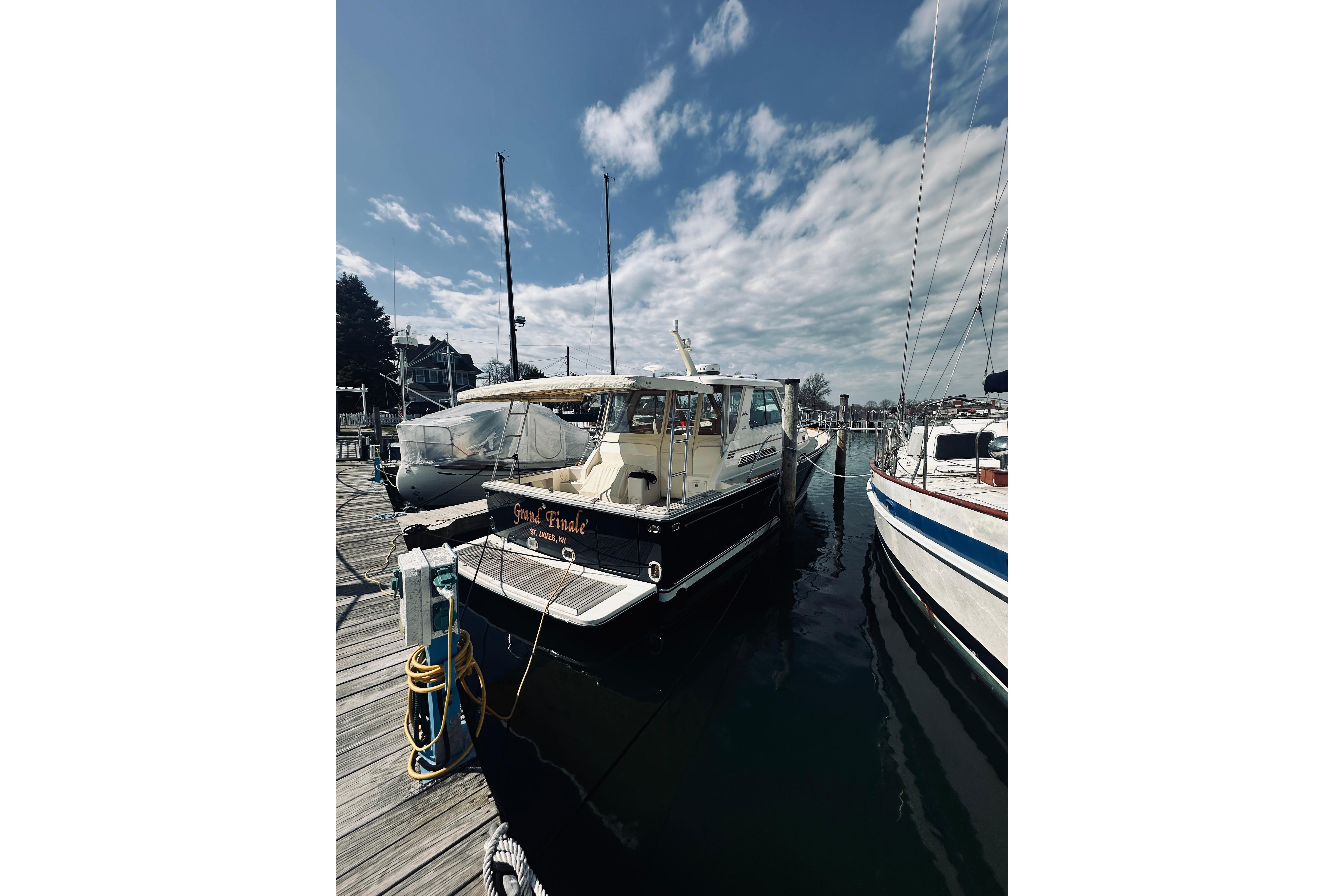 2008 Sabre 38 Hard Top Express docked at marina under blue sky.