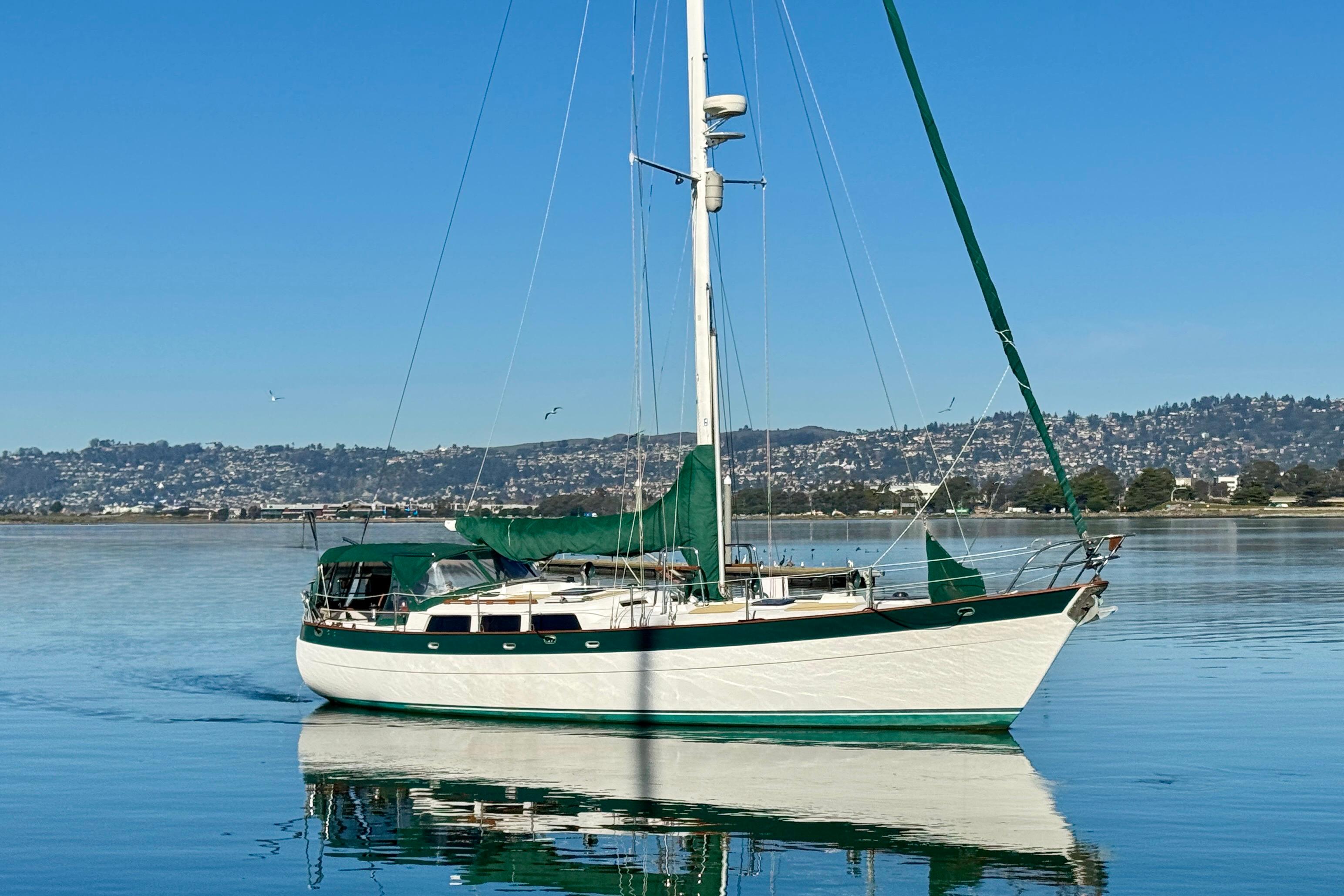 Sailboat Hans Christian Christina 1988 on calm water with scenic background.